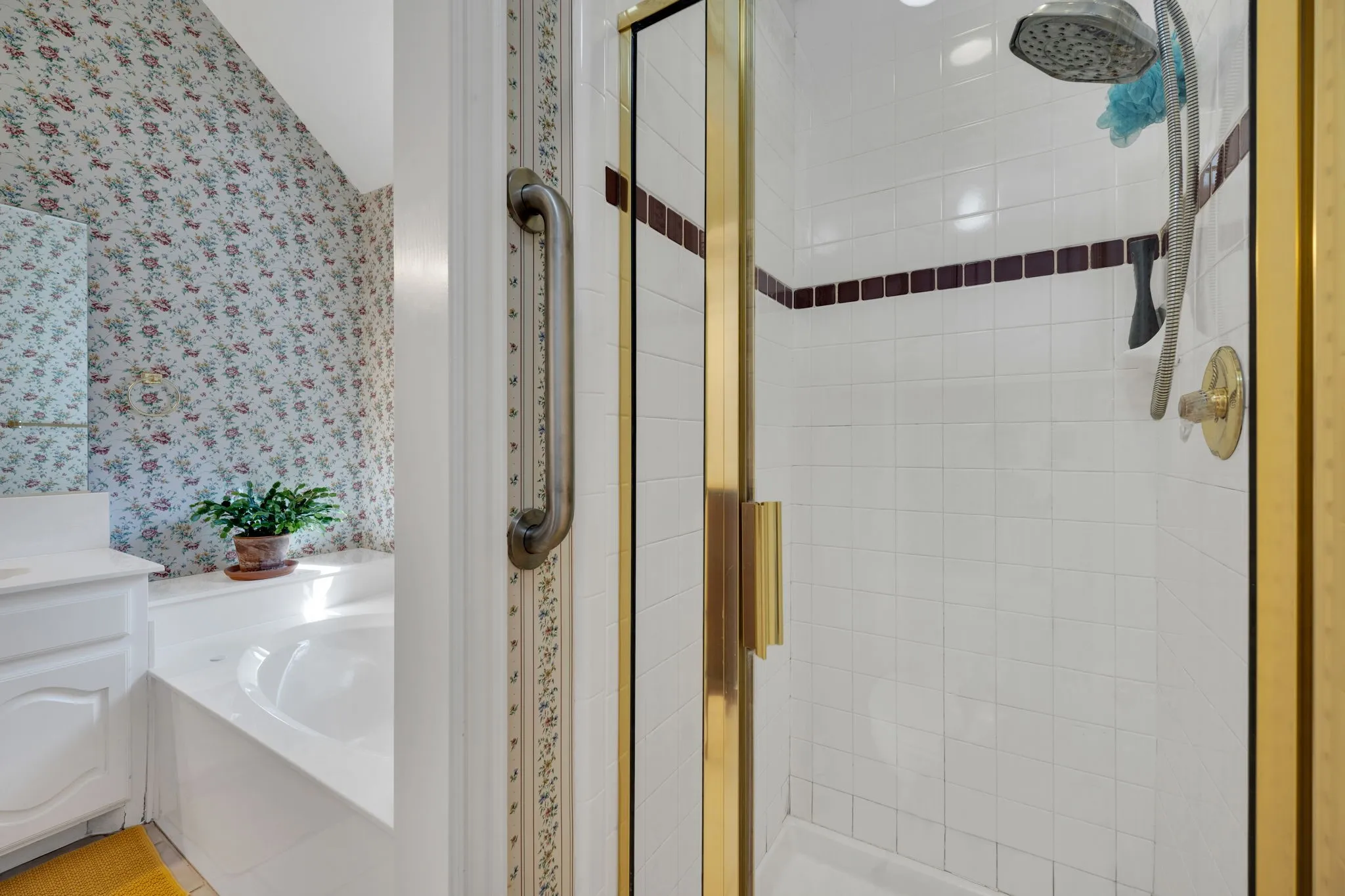 Full bath featuring wallpapered walls, a bath, a stall shower, and vanity