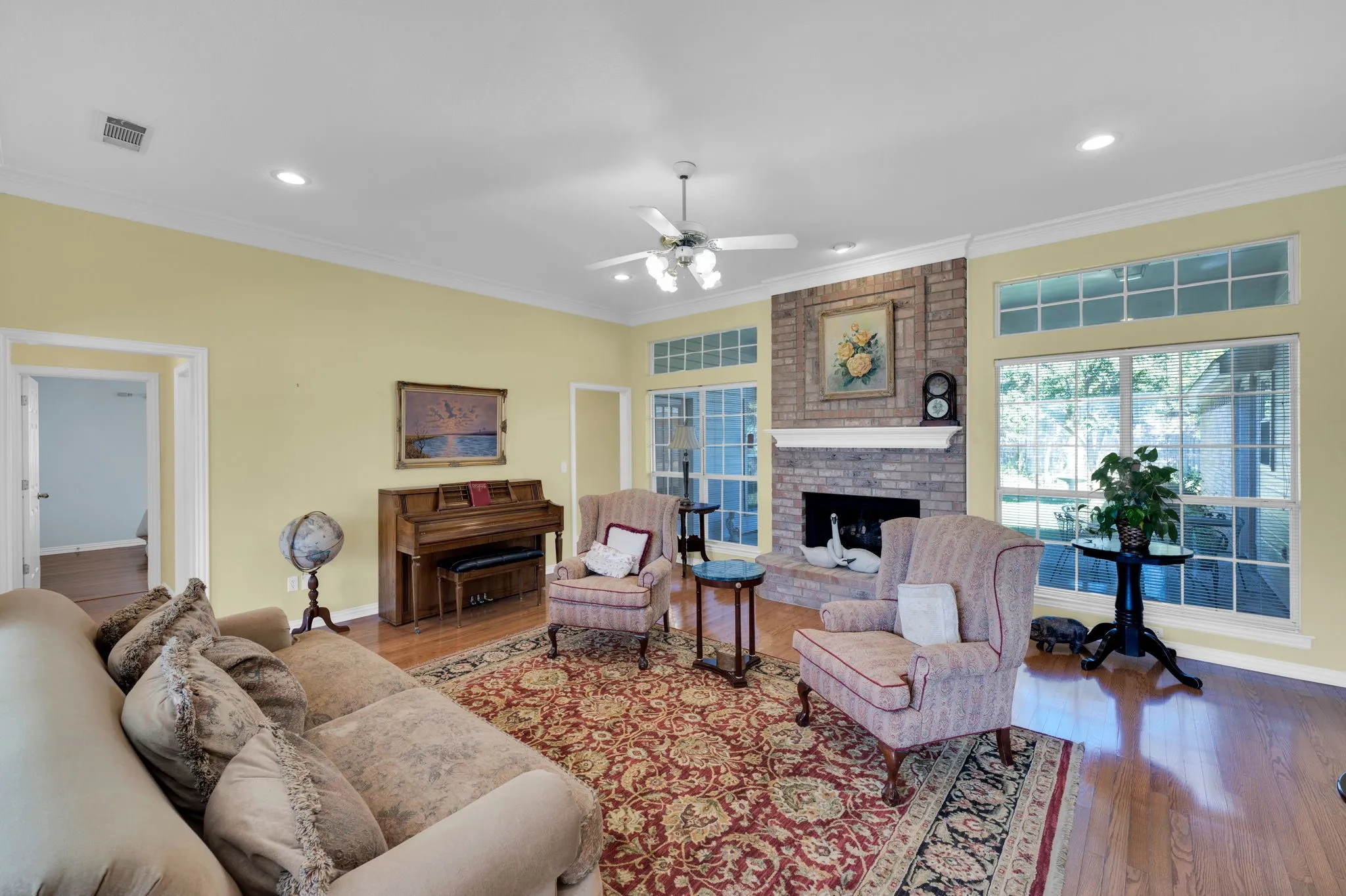 Living room featuring ornamental molding, hardwood / wood-style floors, a fireplace, recessed lighting, and ceiling fan