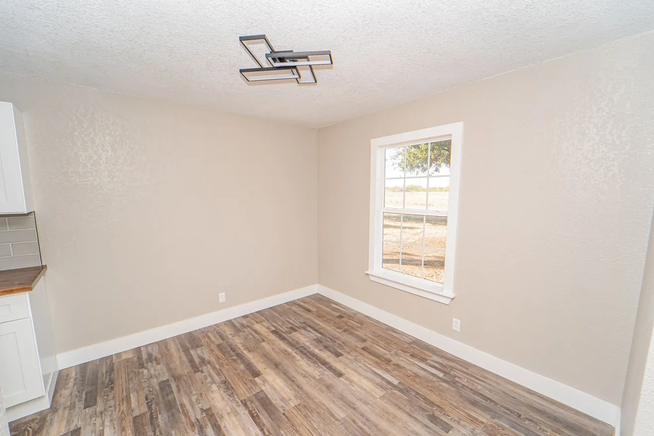 Unfurnished dining area with a textured ceiling, wood finished floors, and a textured wall