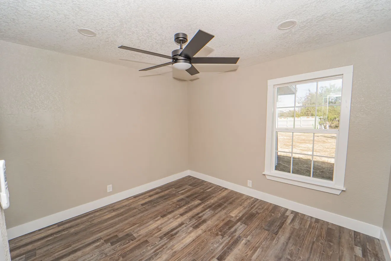 Unfurnished room with a textured ceiling, dark wood-type flooring, ceiling fan, and a textured wall