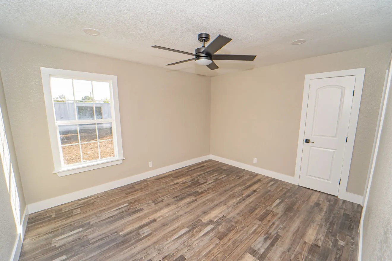Spare room featuring wood finished floors, a textured ceiling, and a ceiling fan