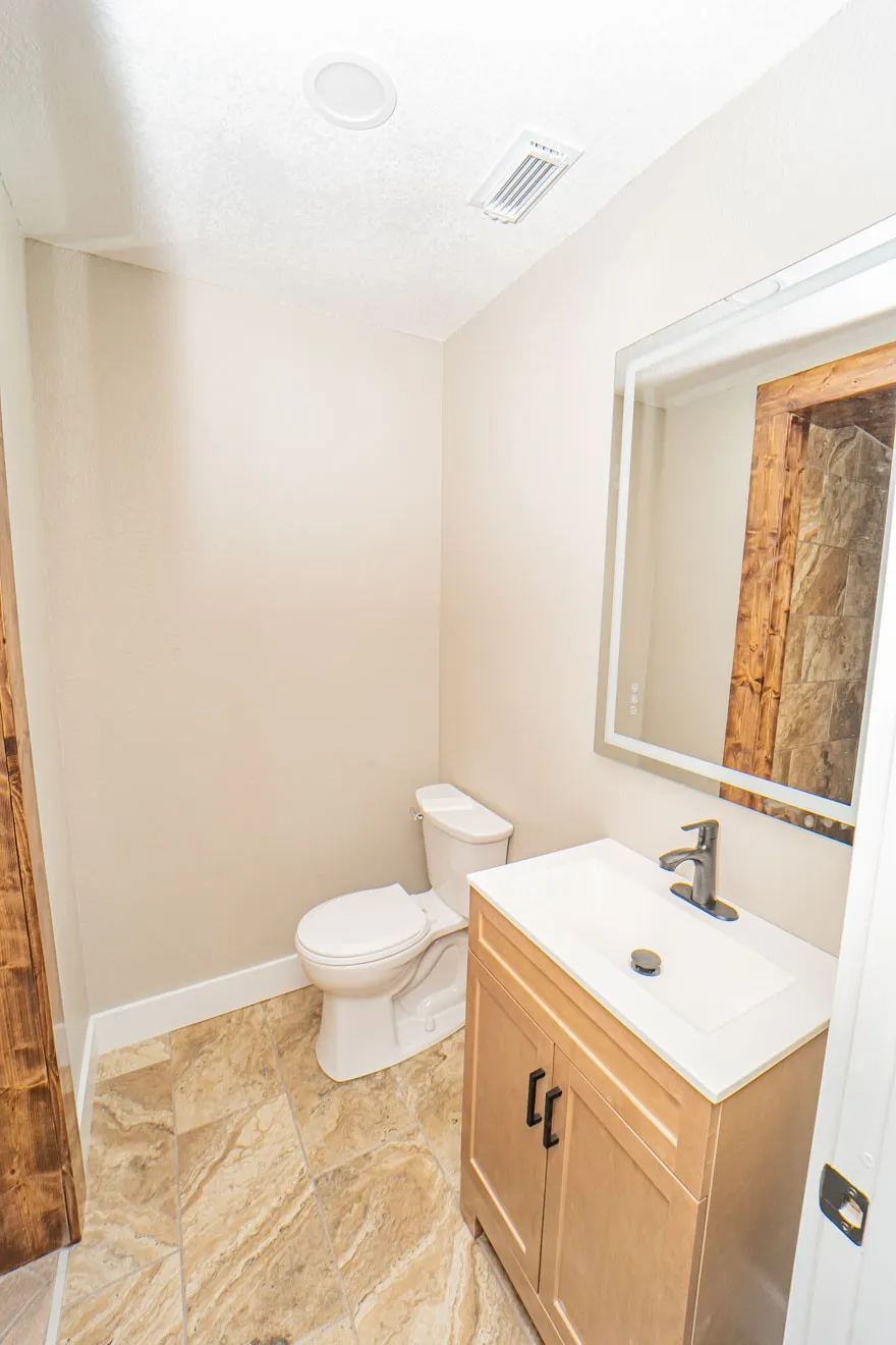 Half bath featuring vanity, a textured ceiling, and light stone finish flooring