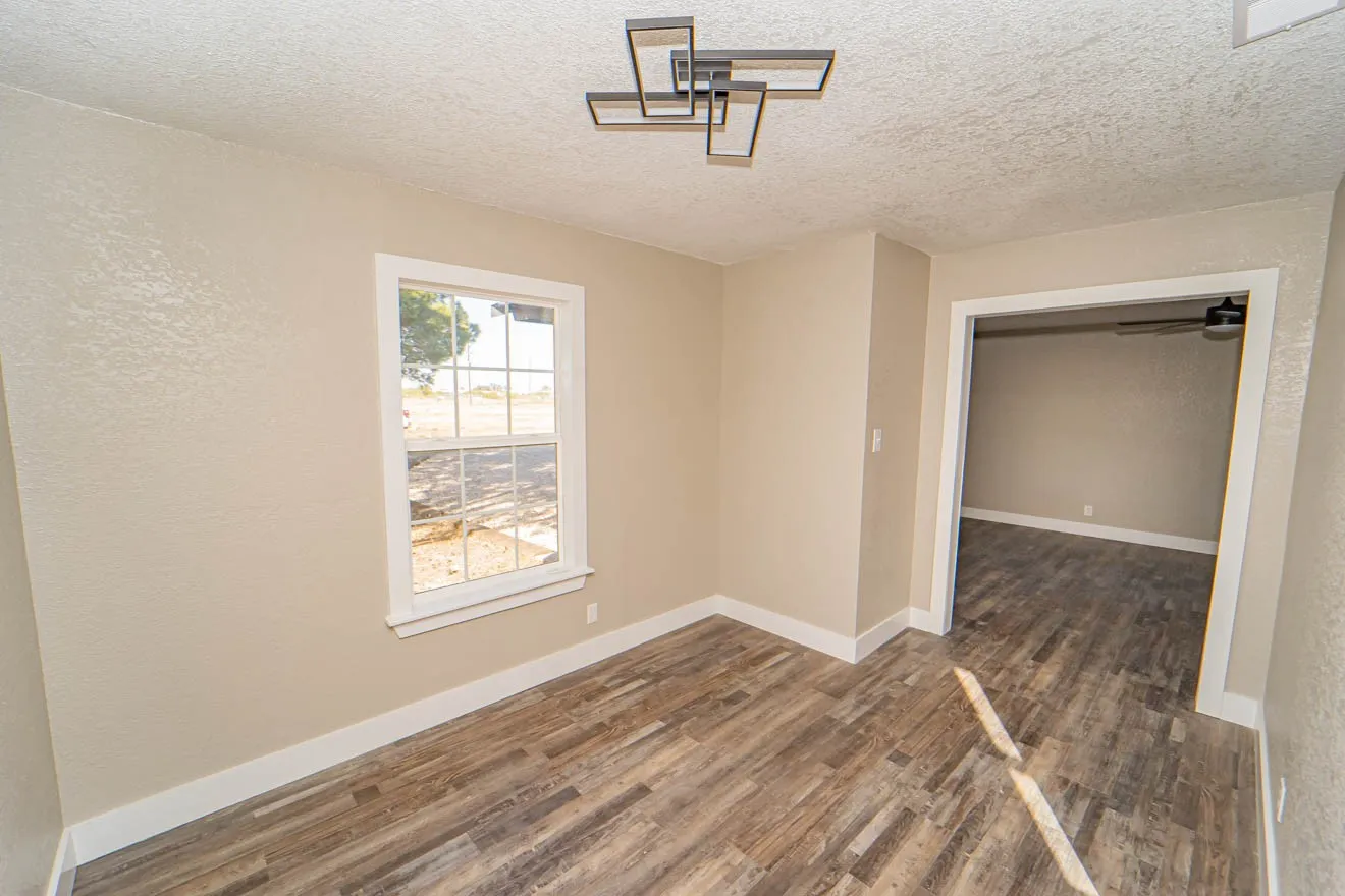 Unfurnished room featuring a textured ceiling, dark wood finished floors, and a textured wall