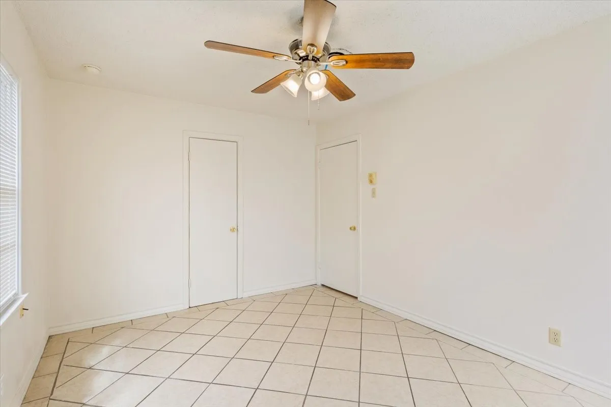 Unfurnished room with a ceiling fan and light tile patterned flooring