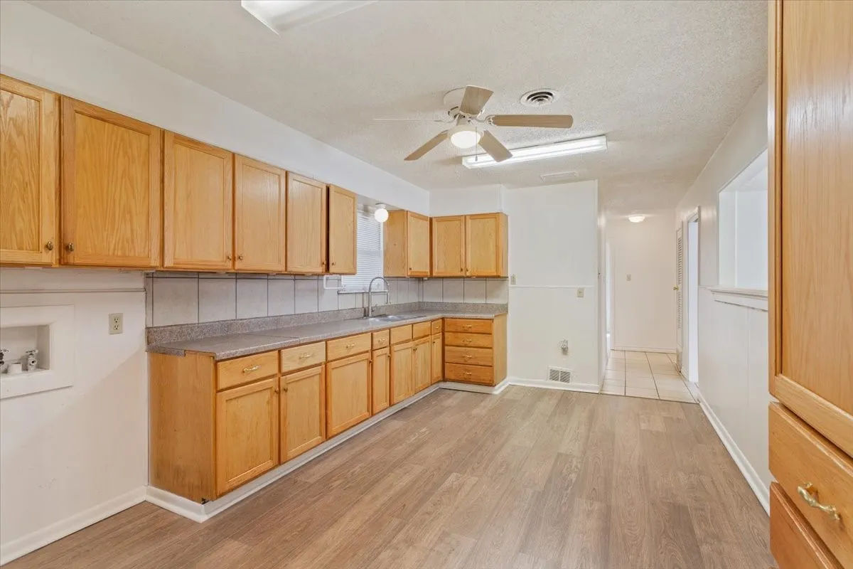 Kitchen featuring light wood-style floors, light brown cabinets, a ceiling fan, light countertops, and a textured ceiling