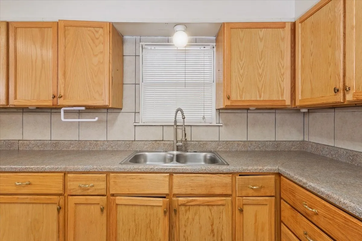 Kitchen with tasteful backsplash and light countertops