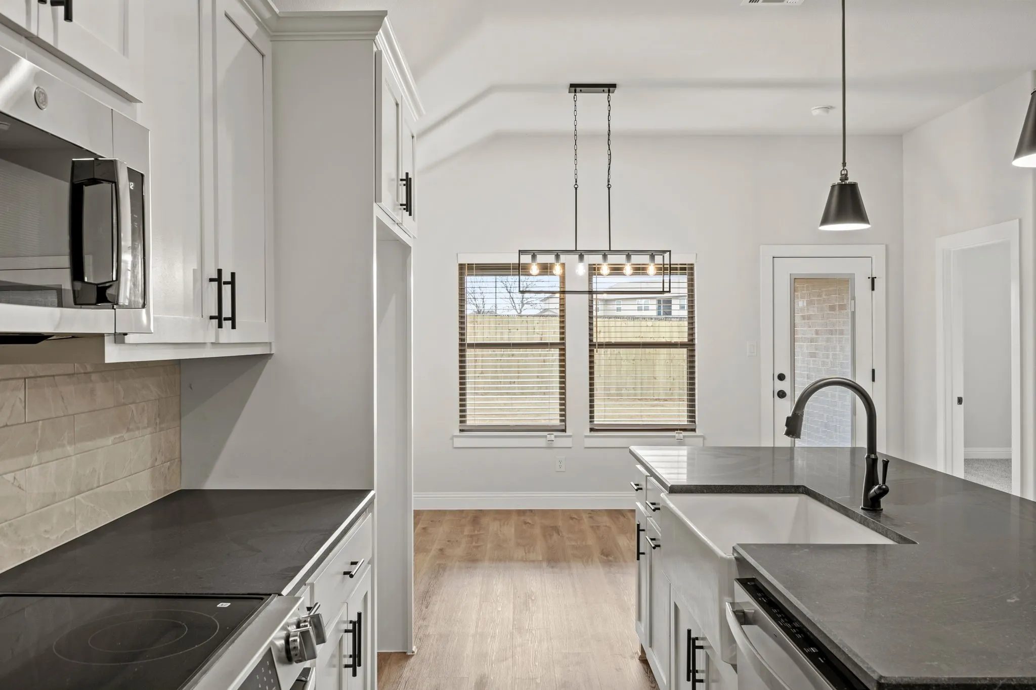 Kitchen with white cabinetry, stainless steel appliances, and pendant lighting