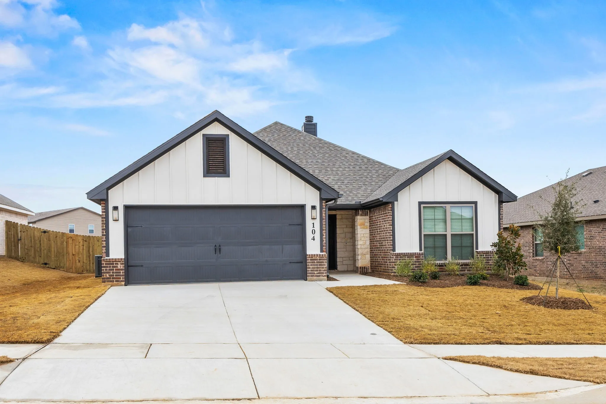 Modern farmhouse with board and batten siding, concrete driveway, a chimney, an attached garage, and roof with shingles
