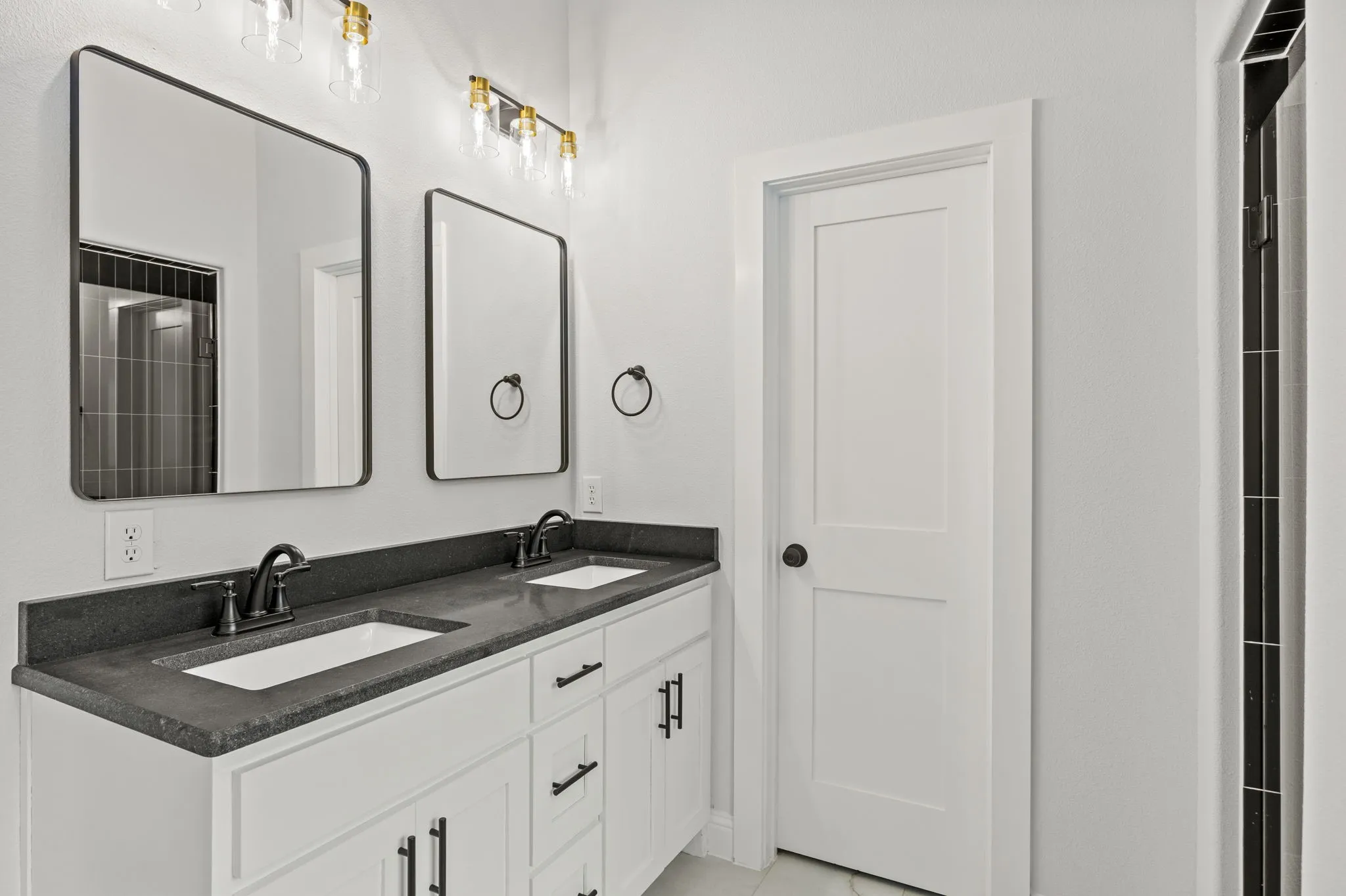 Full bath featuring double vanity and a shower with door