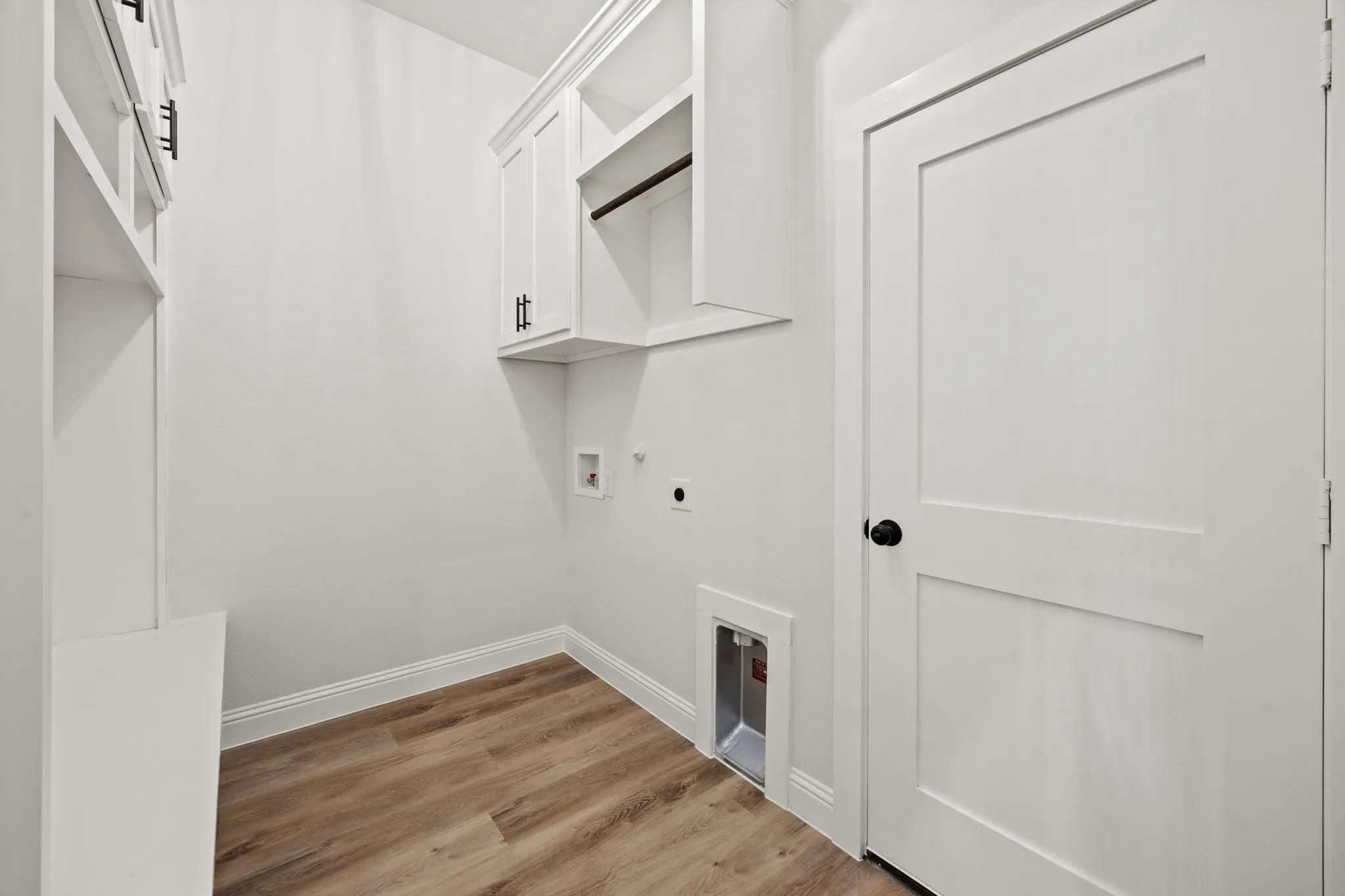 Washroom featuring light wood-type flooring, gas dryer hookup, hookup for a washing machine, hookup for an electric dryer, and cabinet space