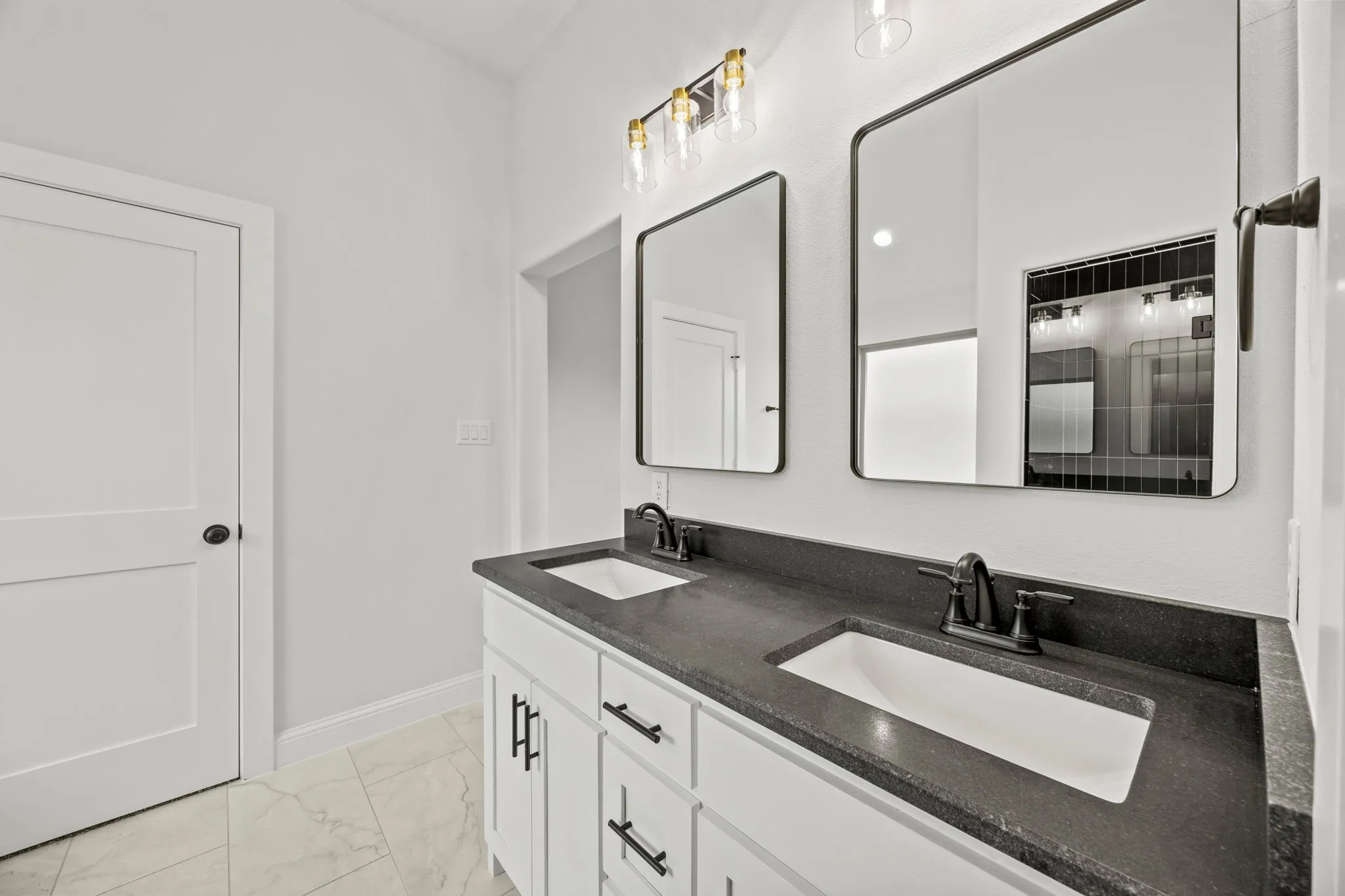 Bathroom featuring double vanity and light marble finish flooring