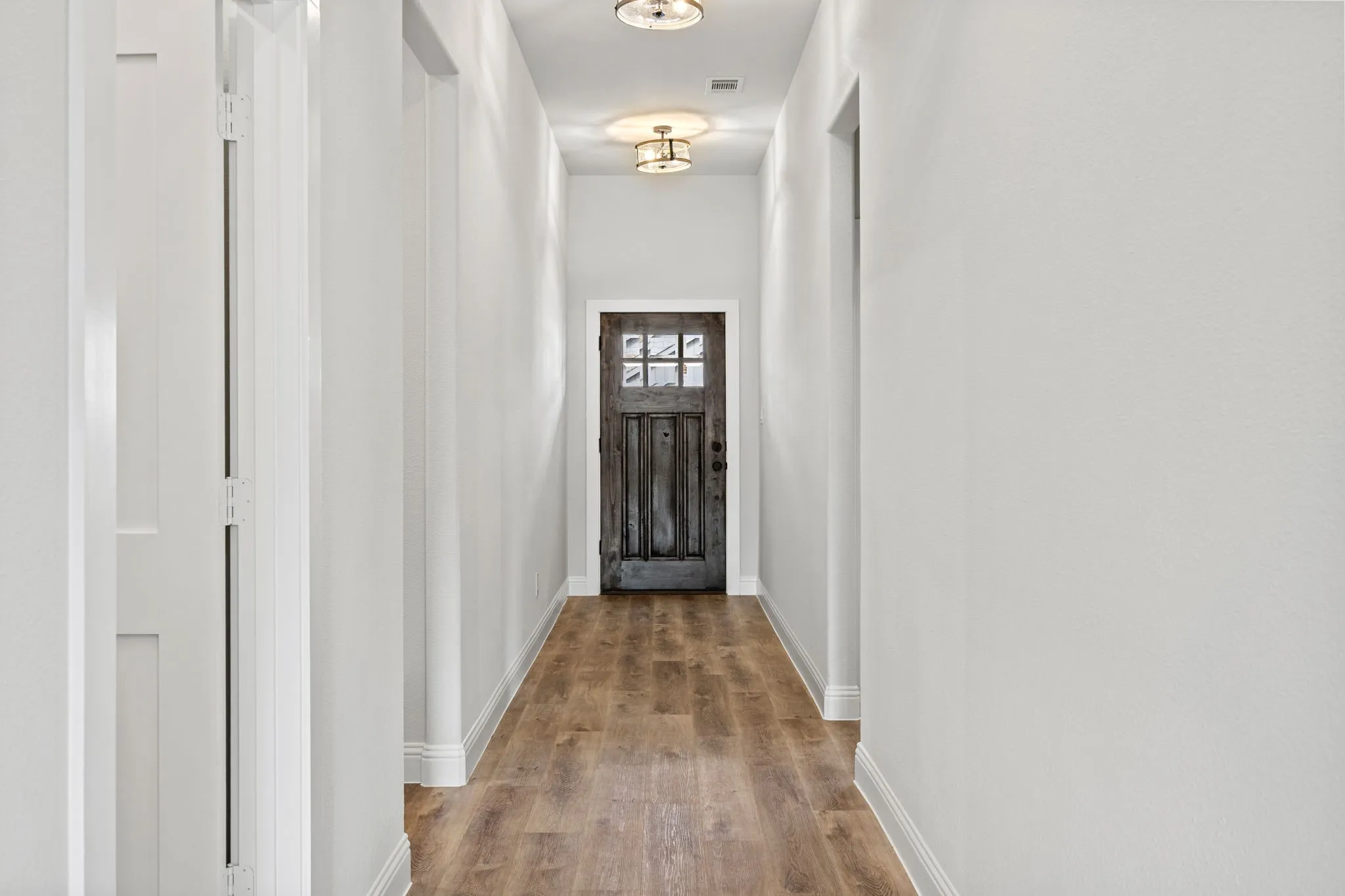 Doorway to outside with wood finished floors and baseboards