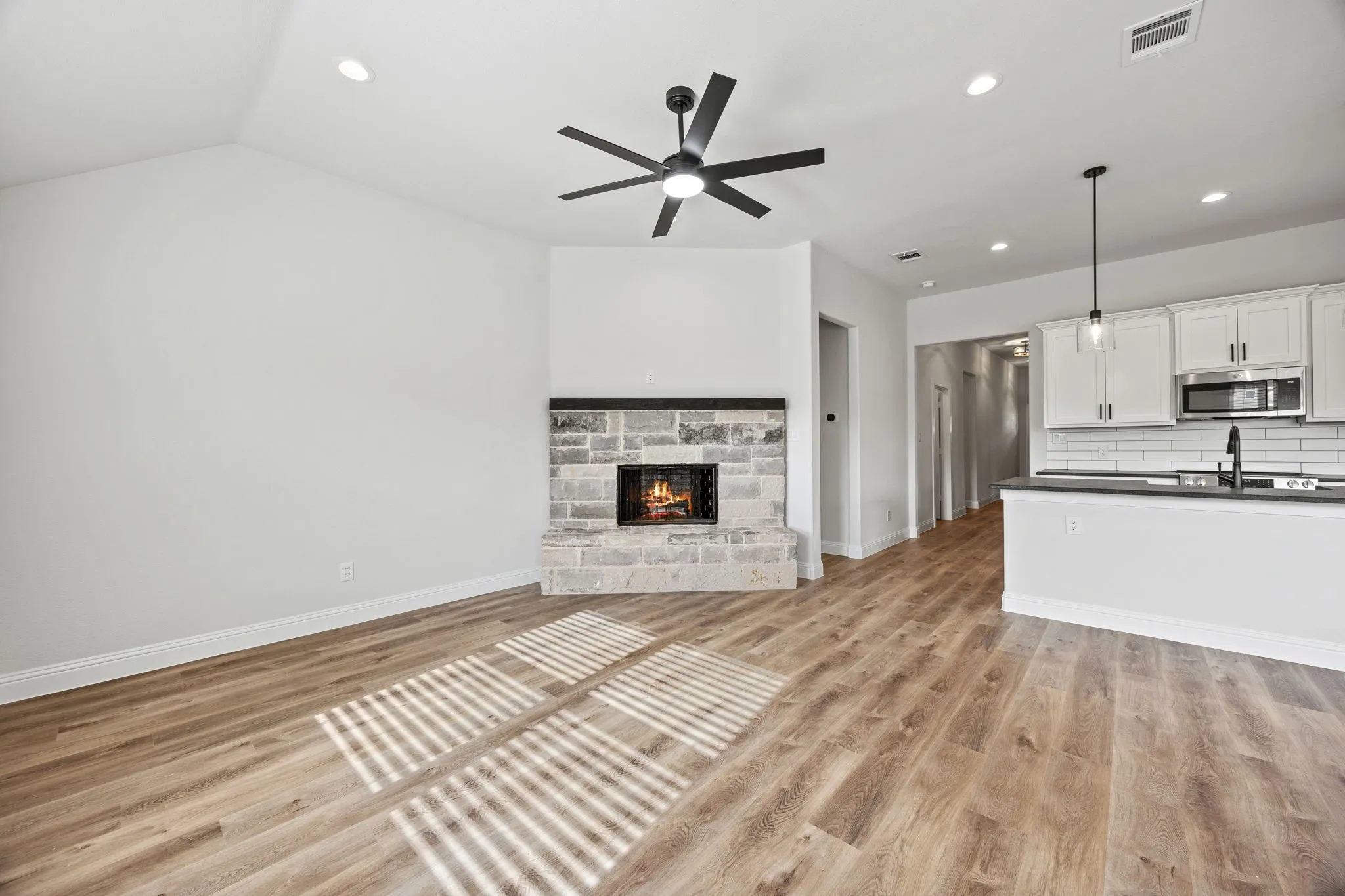 Unfurnished living room featuring light wood finished floors, recessed lighting, a fireplace, and ceiling fan