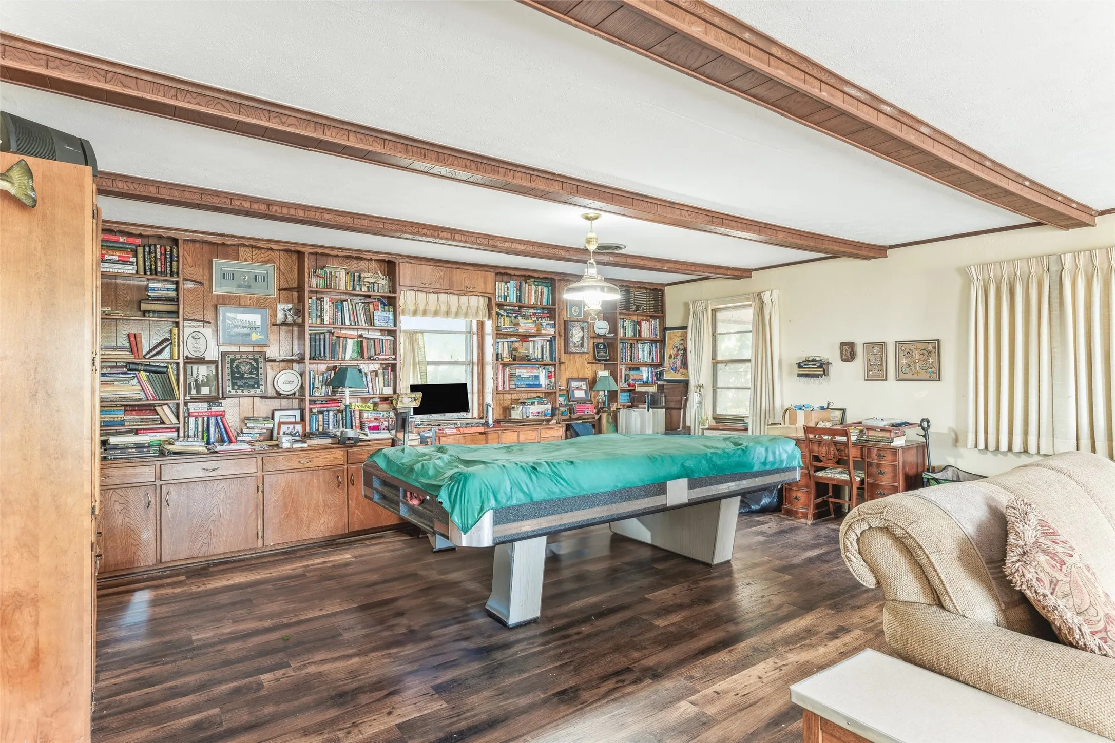 Recreation room with dark wood-style flooring and beamed ceiling