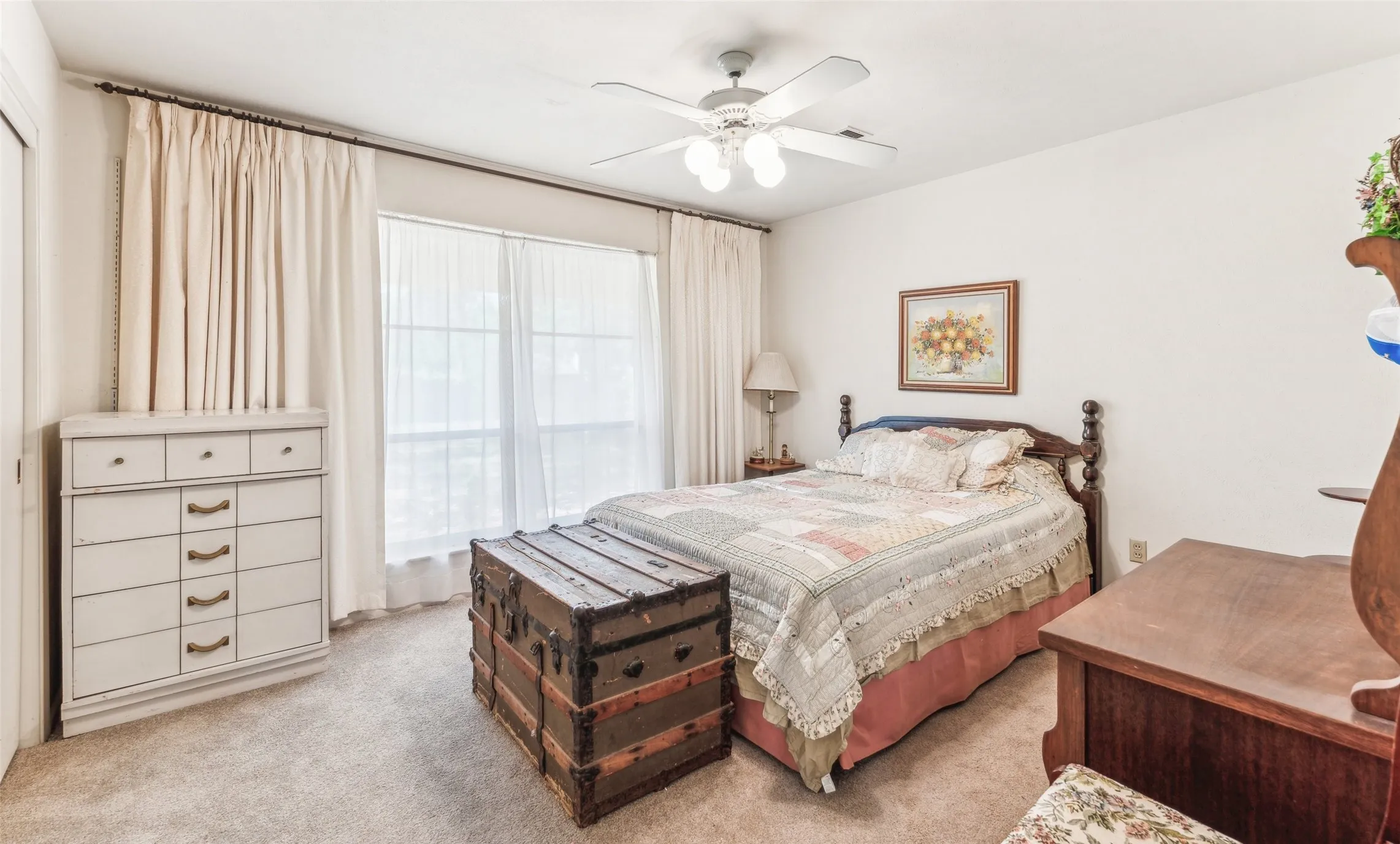 Carpeted bedroom featuring a ceiling fan
