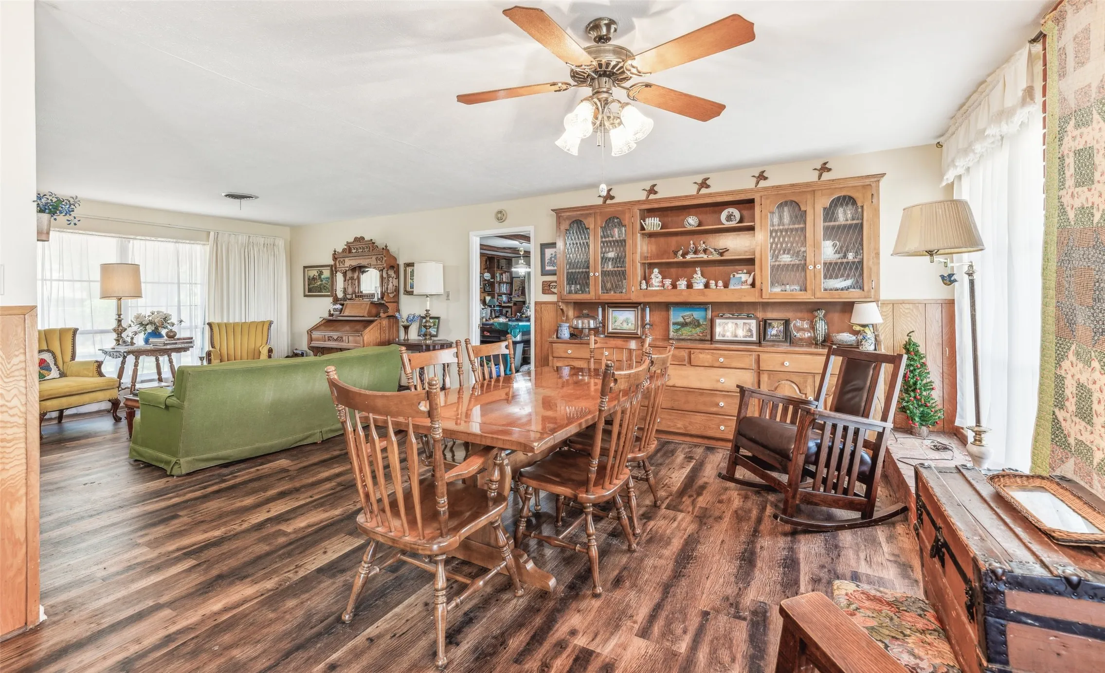 Dining space featuring dark wood-style flooring, plenty of natural light, and a ceiling fan