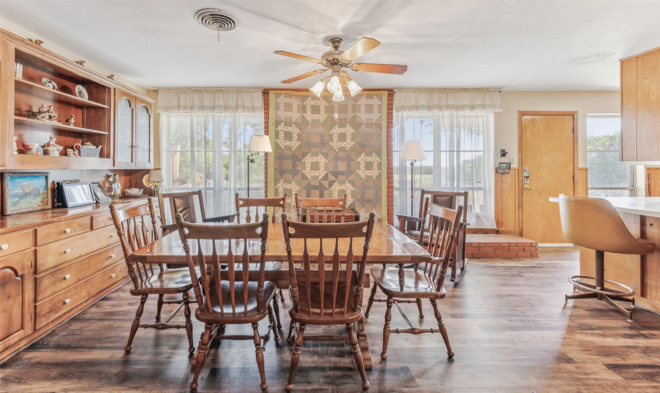 Dining space with plenty of natural light, dark wood-style flooring, and a ceiling fan