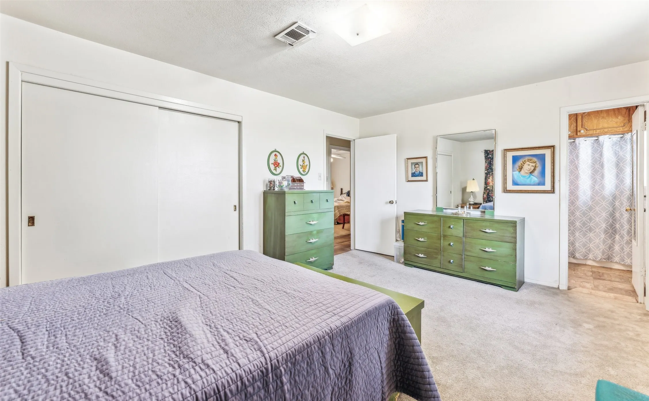 Bedroom featuring carpet floors, a closet, and ensuite bathroom