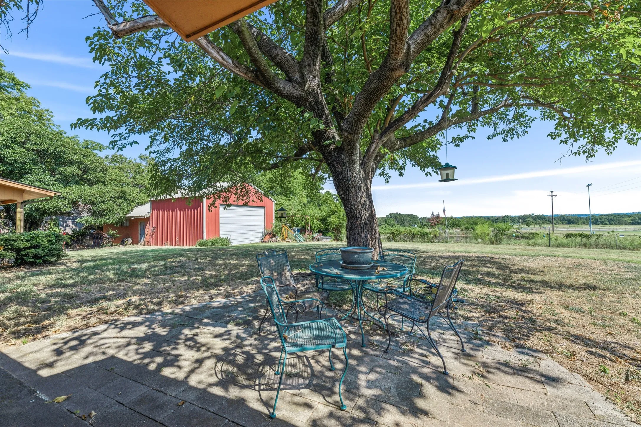 View of patio featuring an outdoor structure, a detached garage, and outdoor dining area