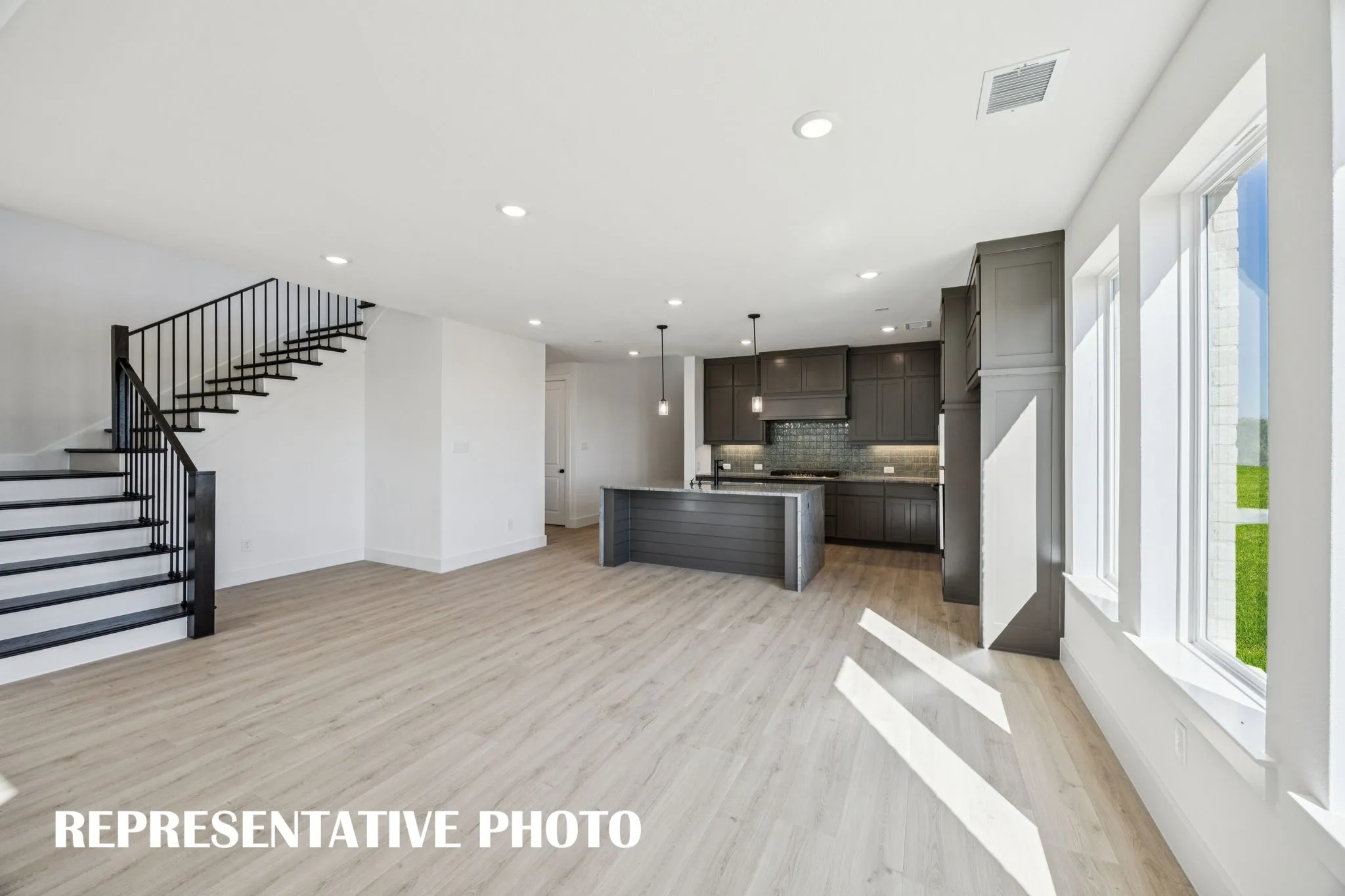 Featuring a view to the outdoors through a wall of windows, this dining room is the perfect setting for lively dinner parties or cozy family meals! REPRESENTATIVE PHOTO