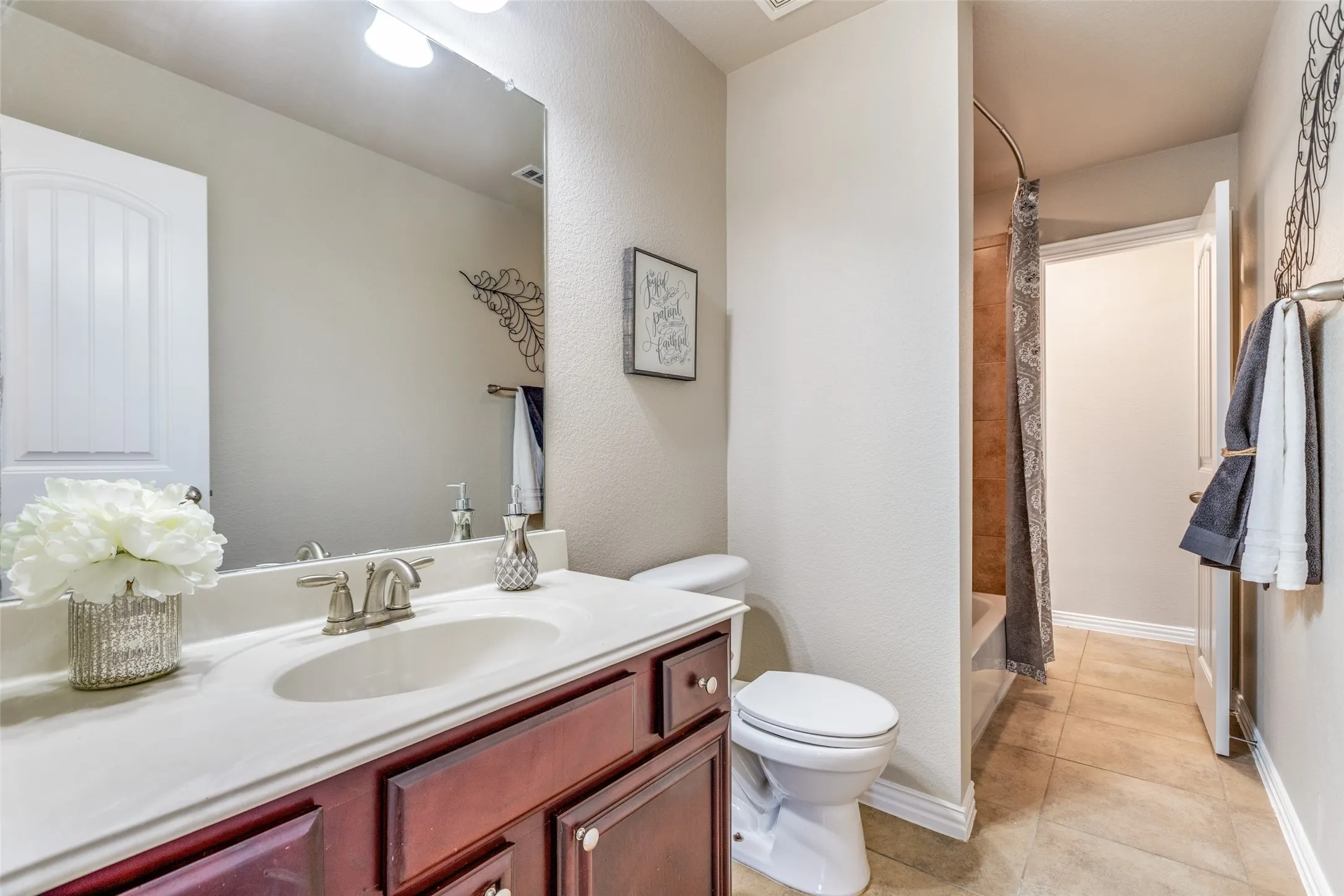 Full bath with vanity, light tile patterned flooring, and shower / bath combination