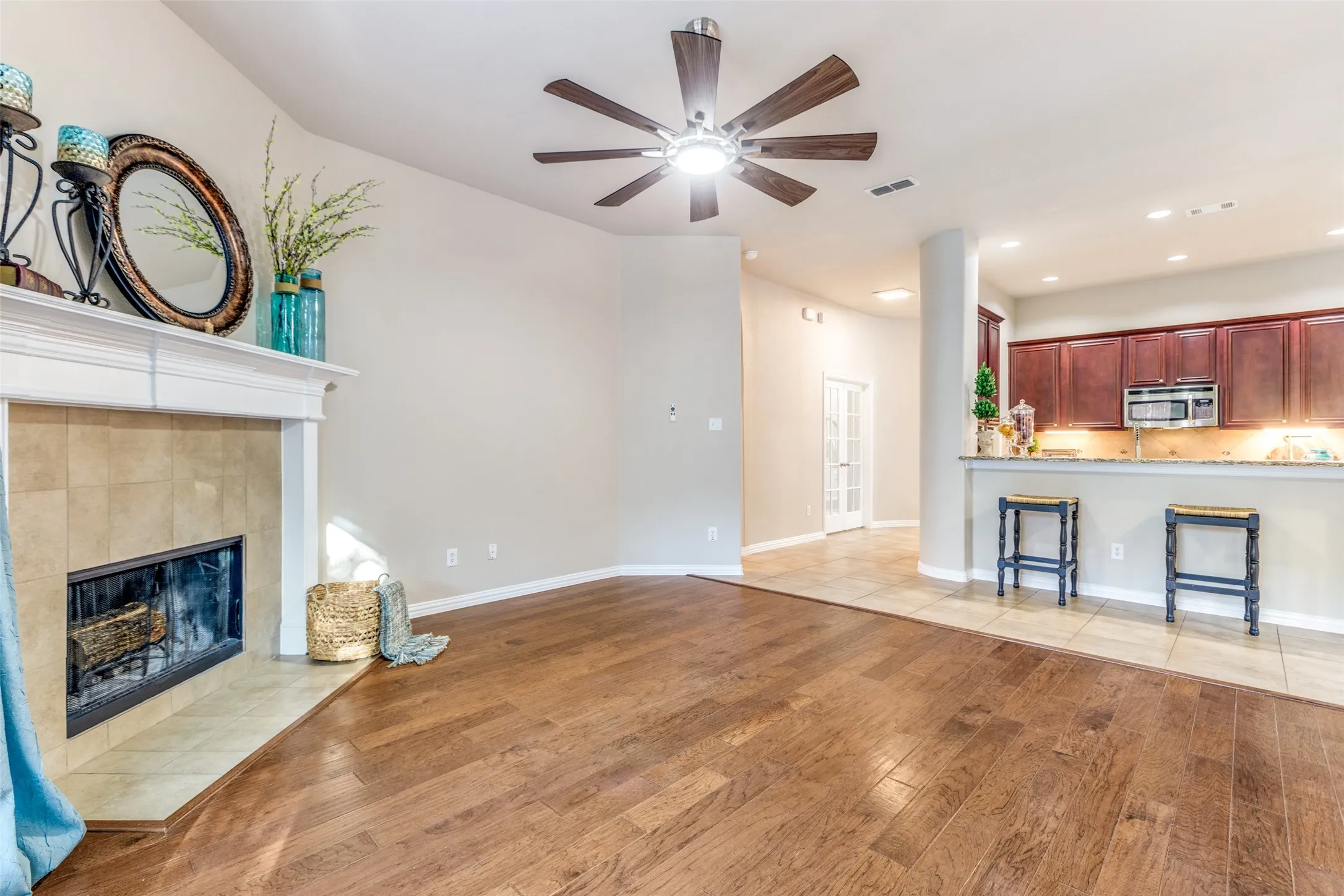 Living room featuring light wood-style floors, recessed lighting, a tiled fireplace, and ceiling fan
