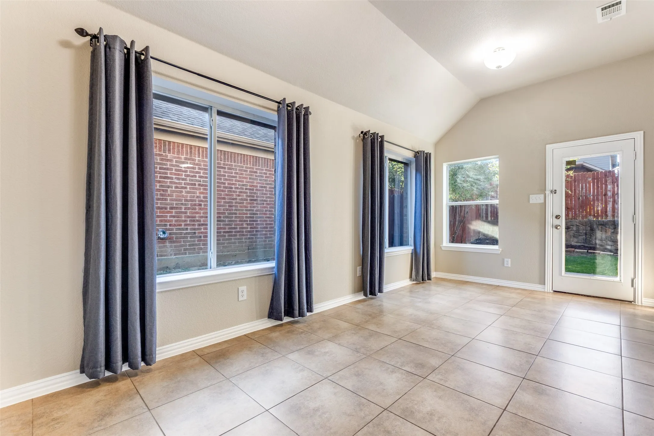 light tile patterned floors and lofted ceiling