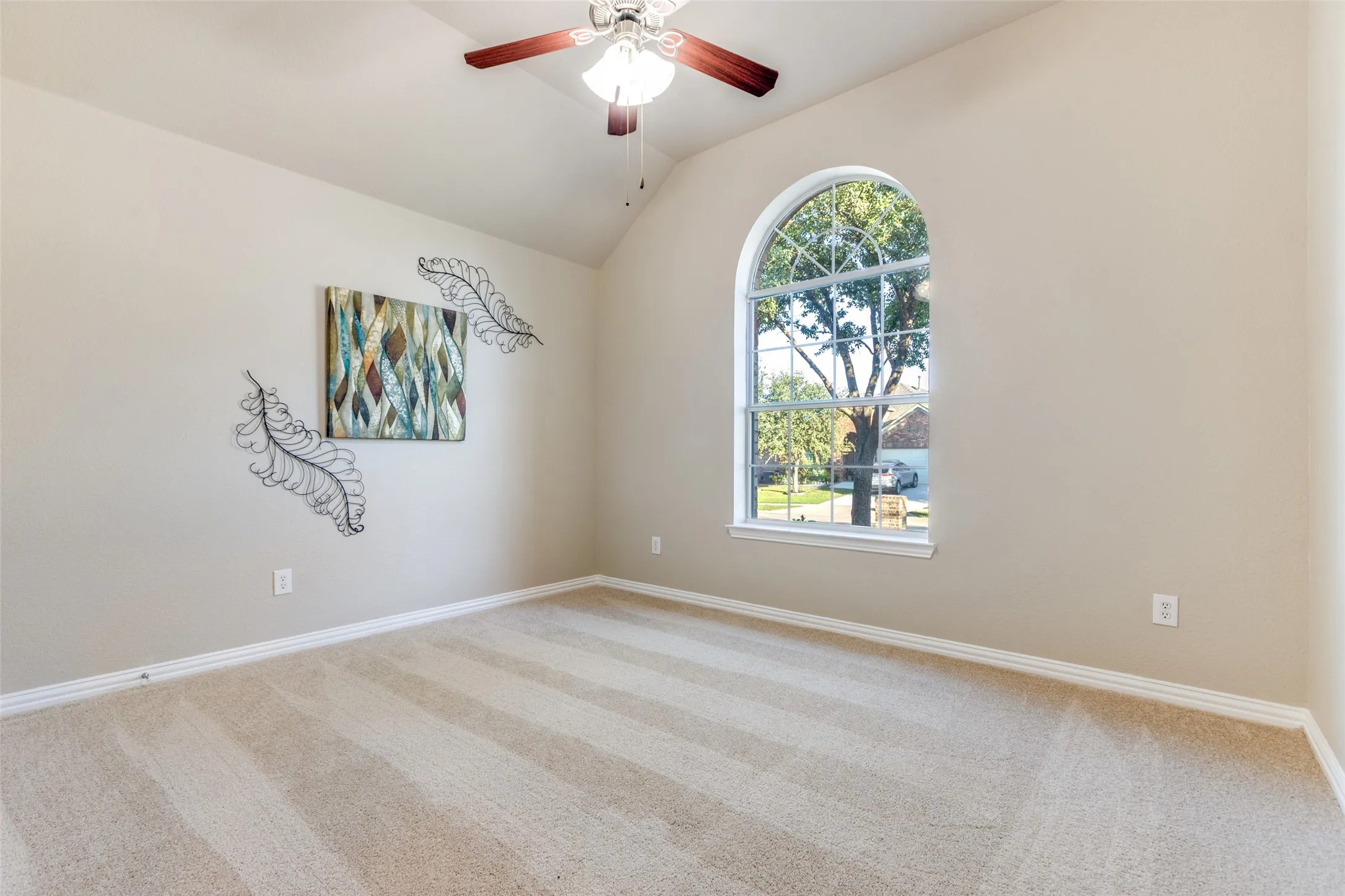 Bedroom with carpet flooring, vaulted ceiling, and a ceiling fan