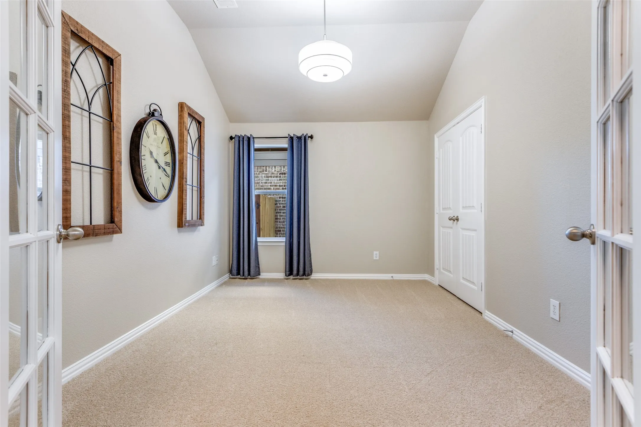 Study or 5th Bedroom  featuring french doors, vaulted ceiling ,closet and light carpet