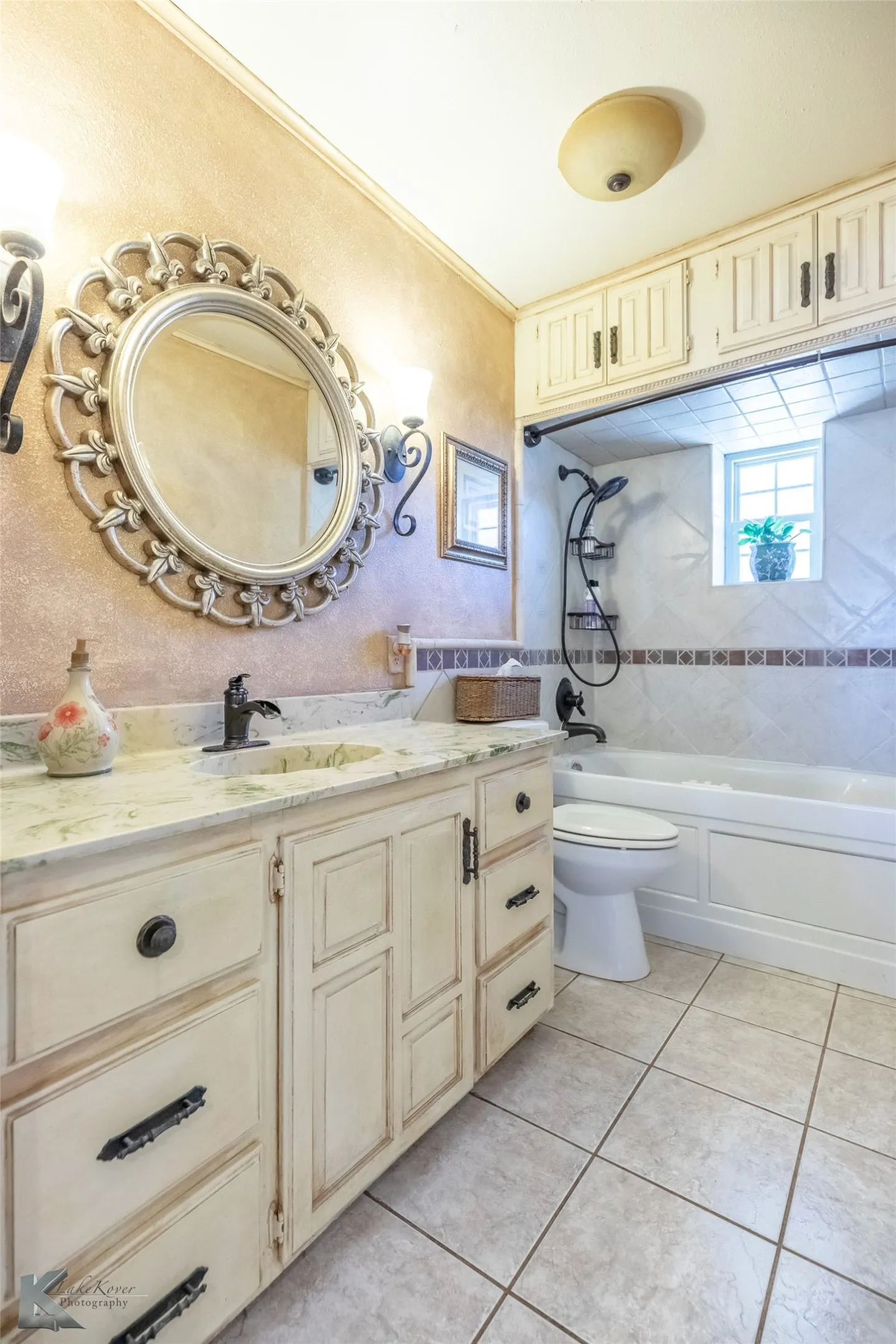 Full bathroom featuring a textured wall, vanity, light tile patterned floors, shower / washtub combination, and crown molding
