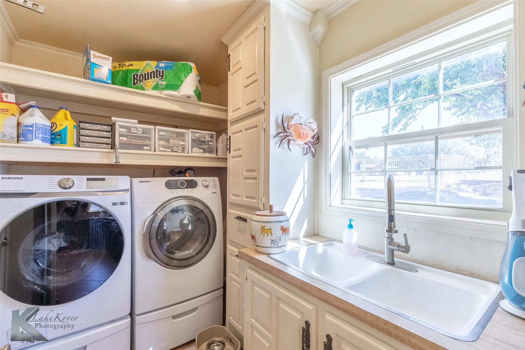 Laundry room with washing machine and clothes dryer and crown molding