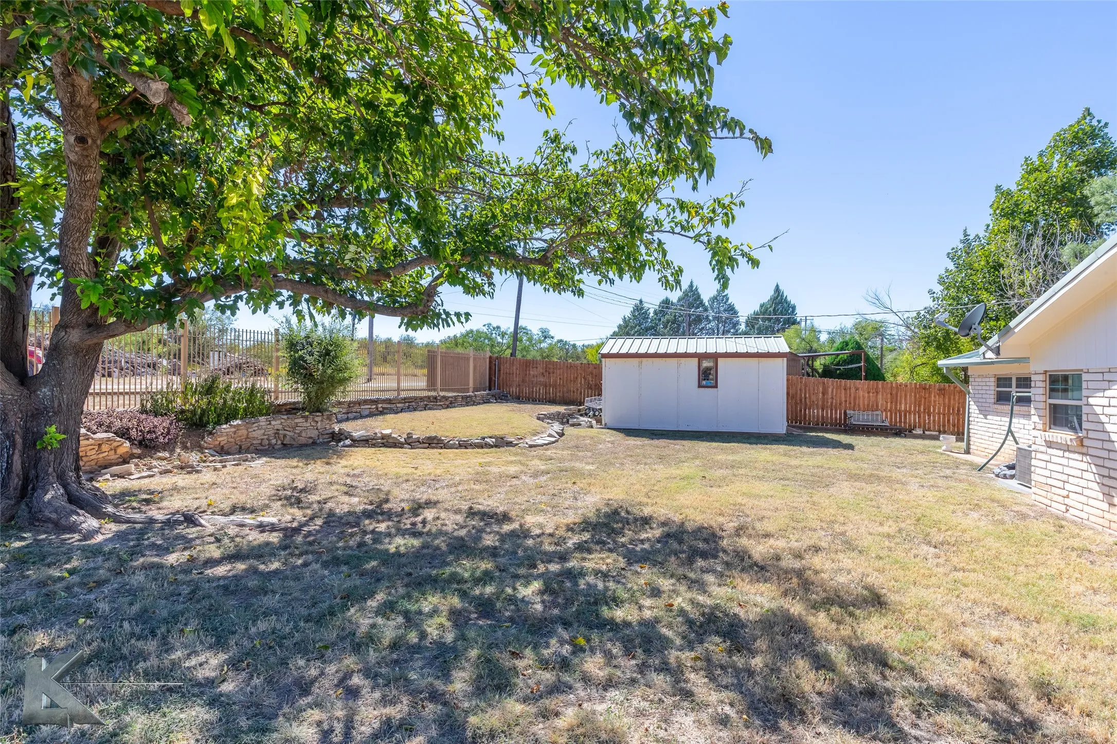 Fenced backyard with an outbuilding