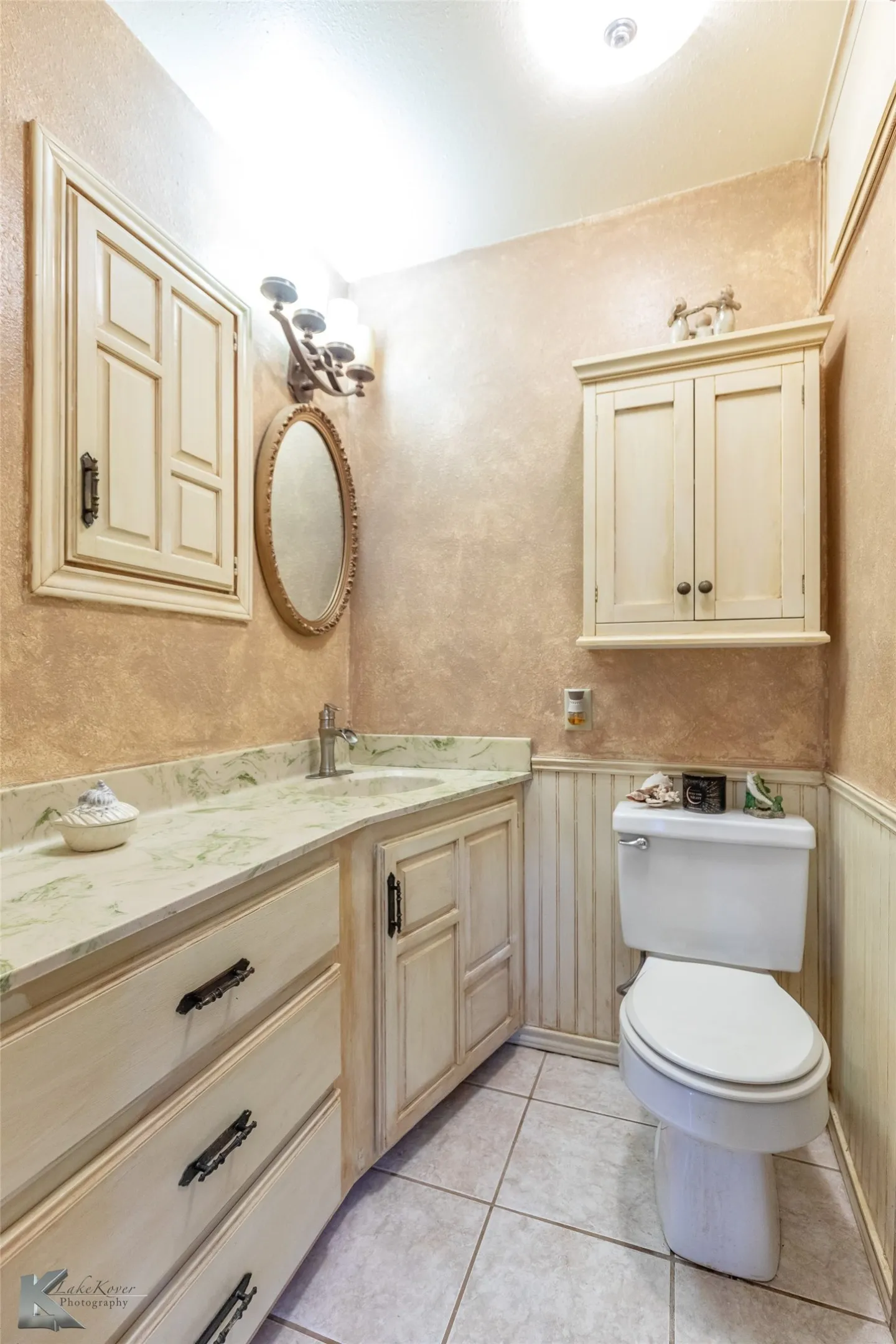 Bathroom featuring vanity, a wainscoted wall, and light tile patterned floors