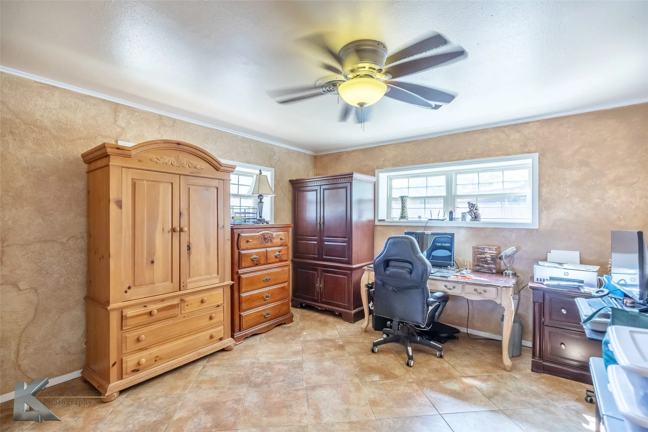 Office space with ceiling fan, a textured wall, and crown molding