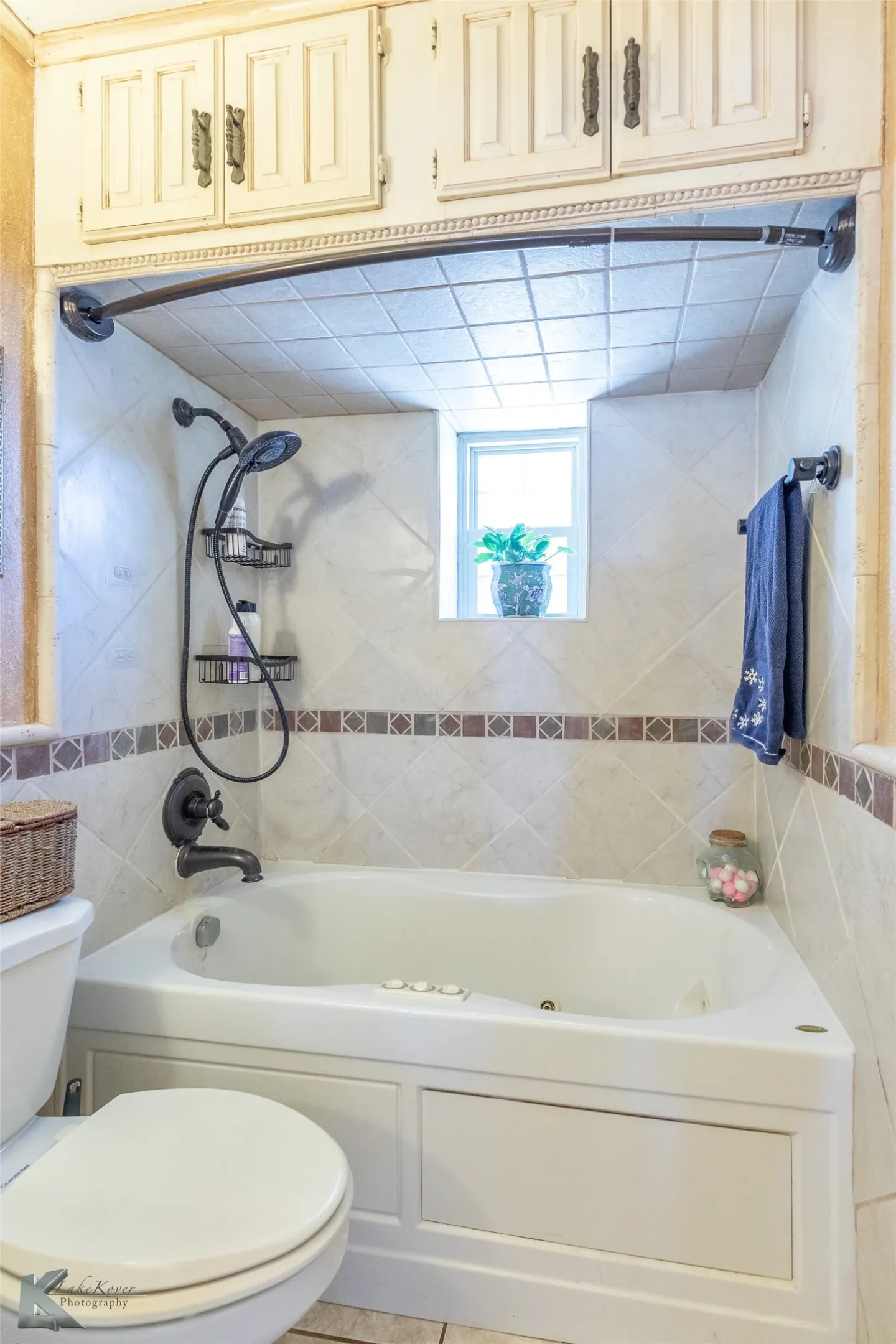 Full bath featuring toilet and light tile patterned flooring