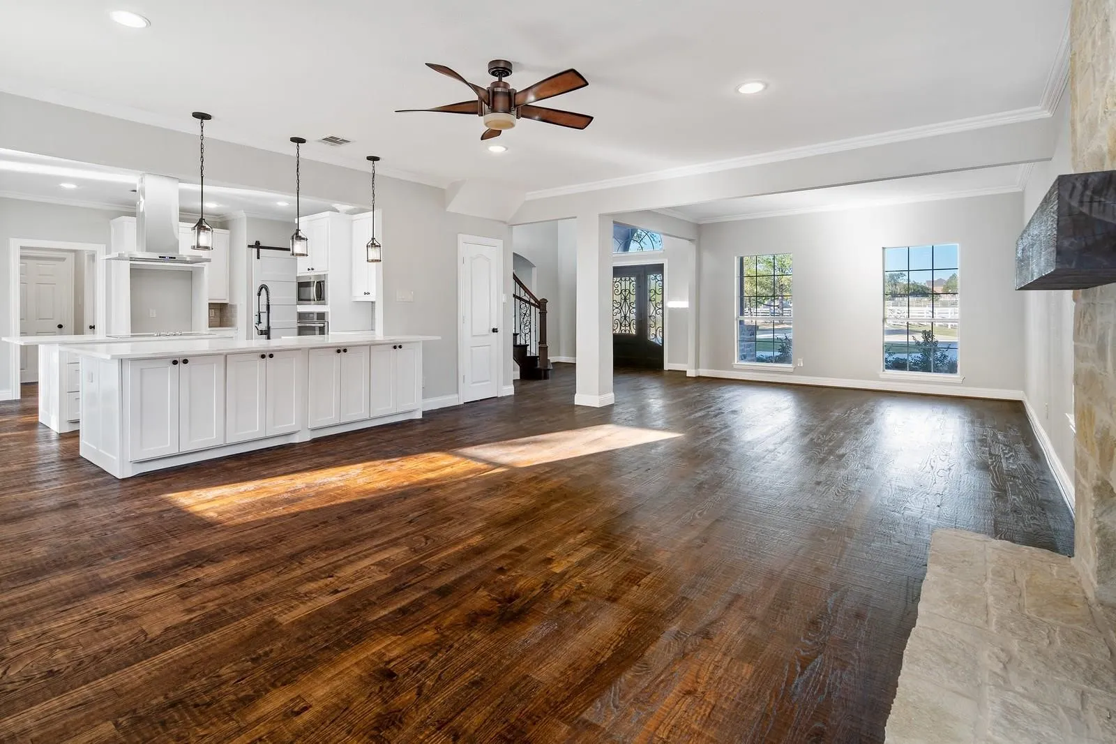 Unfurnished living room featuring crown molding, dark wood-style floors, ceiling fan, stairs, and recessed lighting
