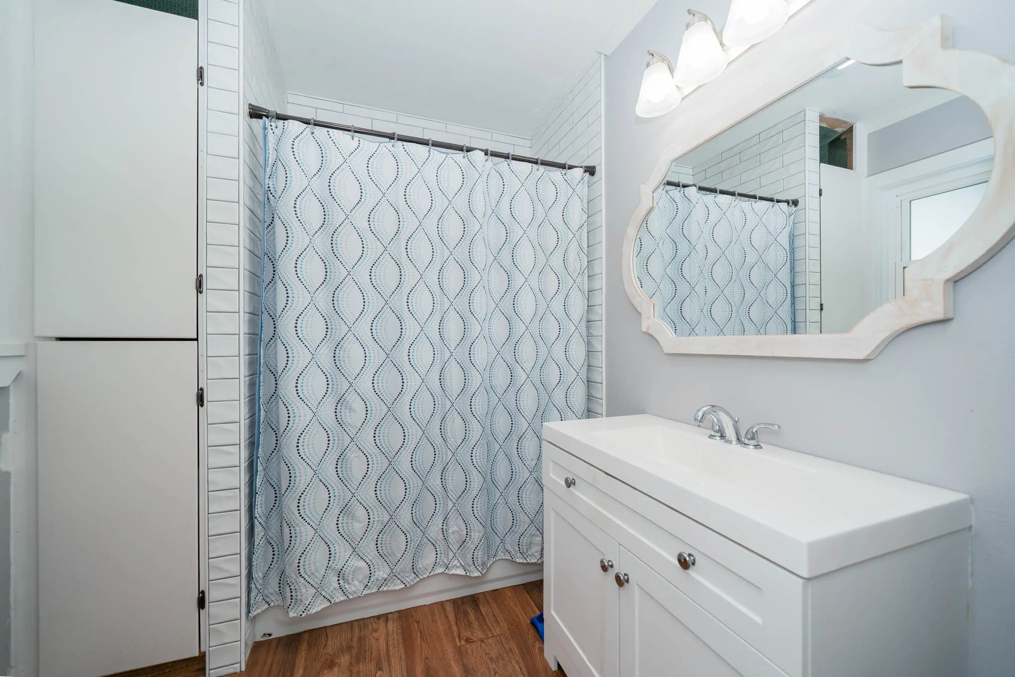 Bathroom featuring vanity, dark wood-type flooring, and curtained shower