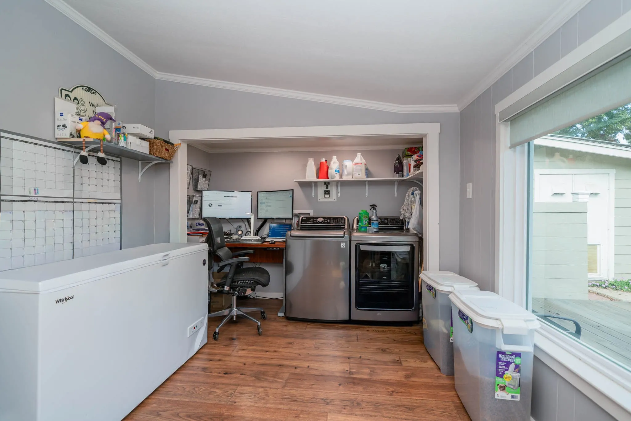 Office space featuring wood finished floors, crown molding, and washing machine and dryer