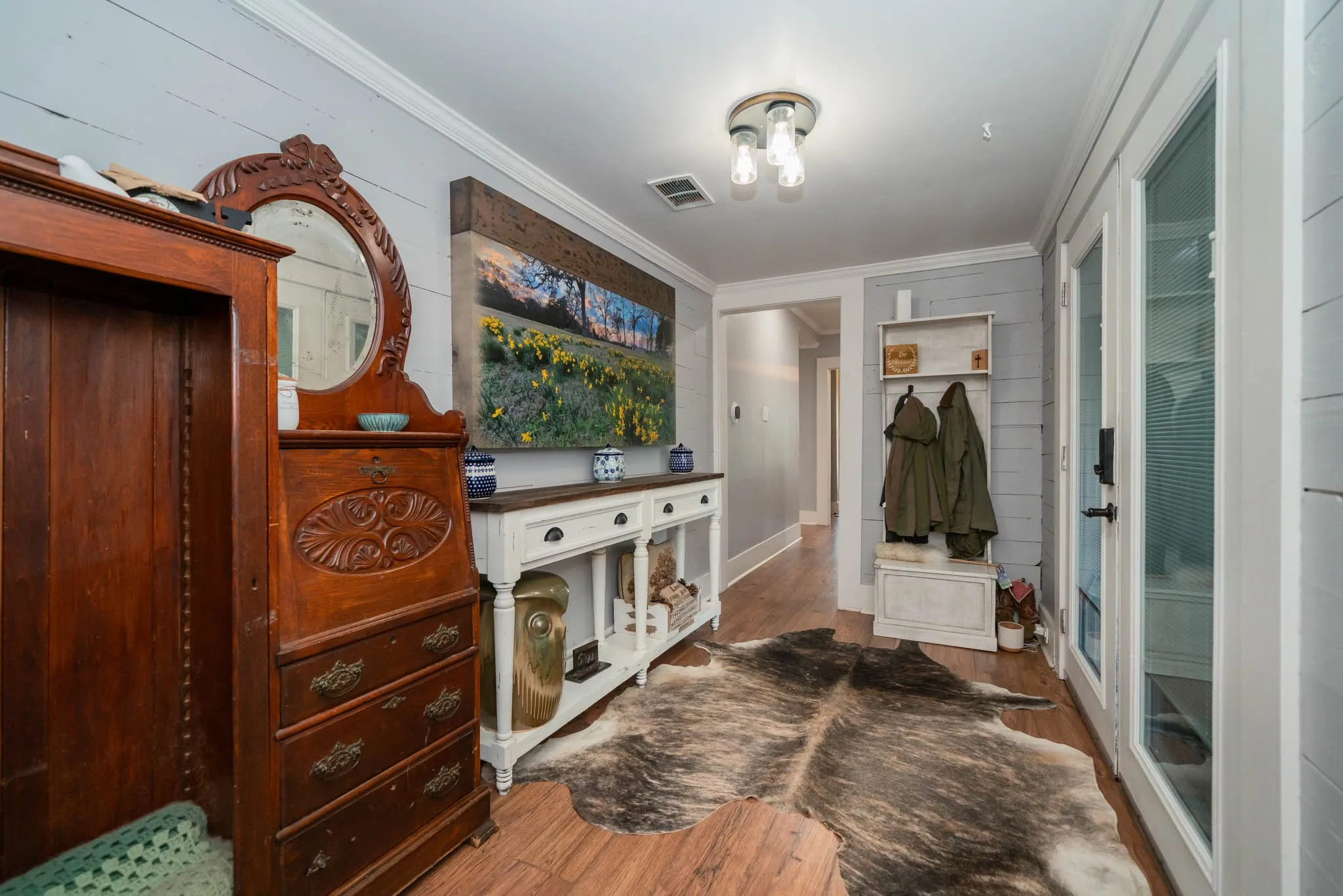 Mudroom featuring wood finished floors and crown molding