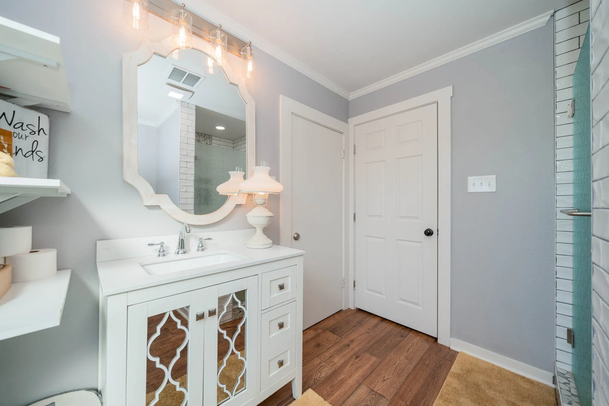 Bathroom with dark wood-style flooring, crown molding, and vanity