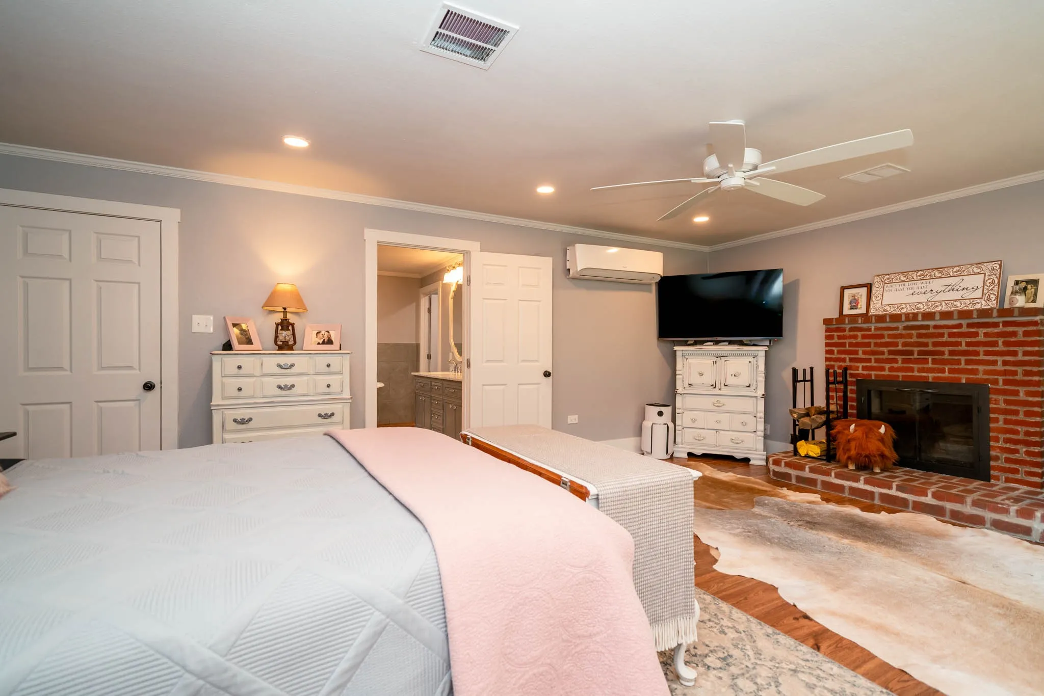 Bedroom with ornamental molding, wood finished floors, recessed lighting, a fireplace, and ceiling fan