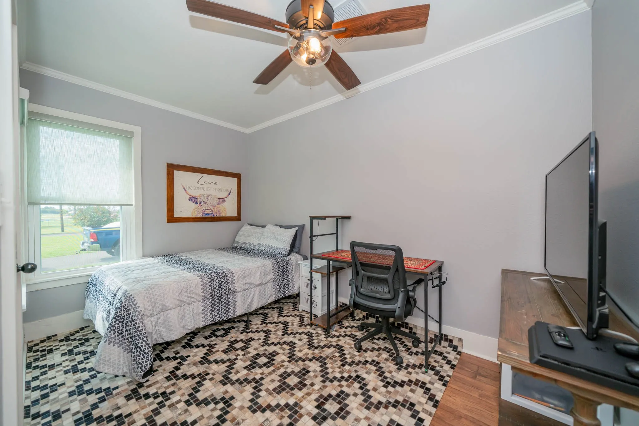 Bedroom featuring ornamental molding, wood finished floors, a ceiling fan, and an office area