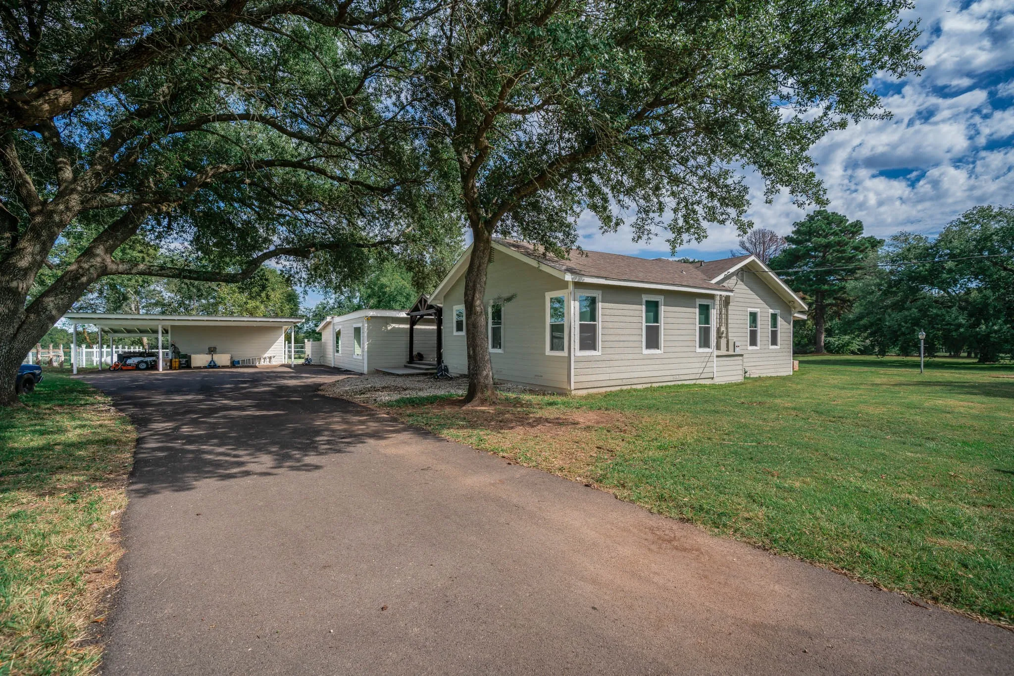 View of side of property with driveway, a yard, and a carport