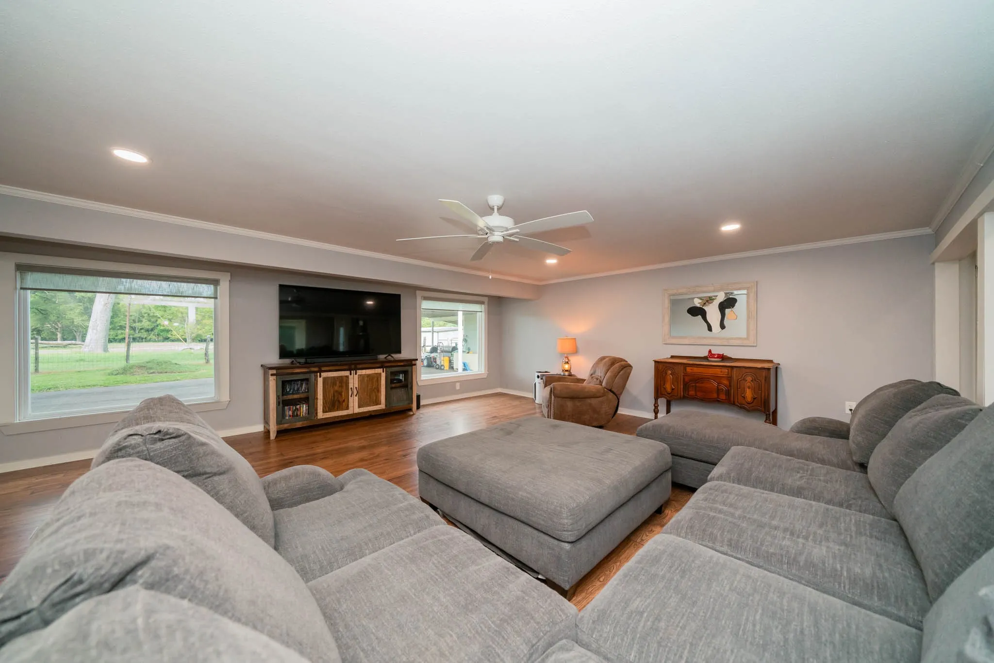 Living room with ornamental molding, recessed lighting, wood finished floors, and a ceiling fan