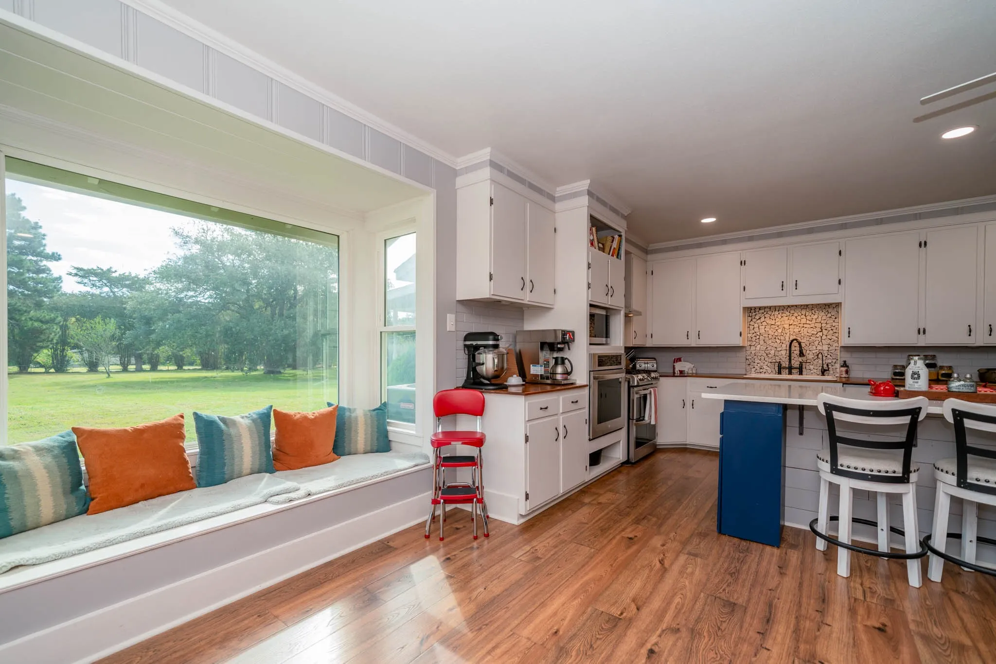 Kitchen with a breakfast bar, white cabinets, tasteful backsplash, recessed lighting, and ornamental molding