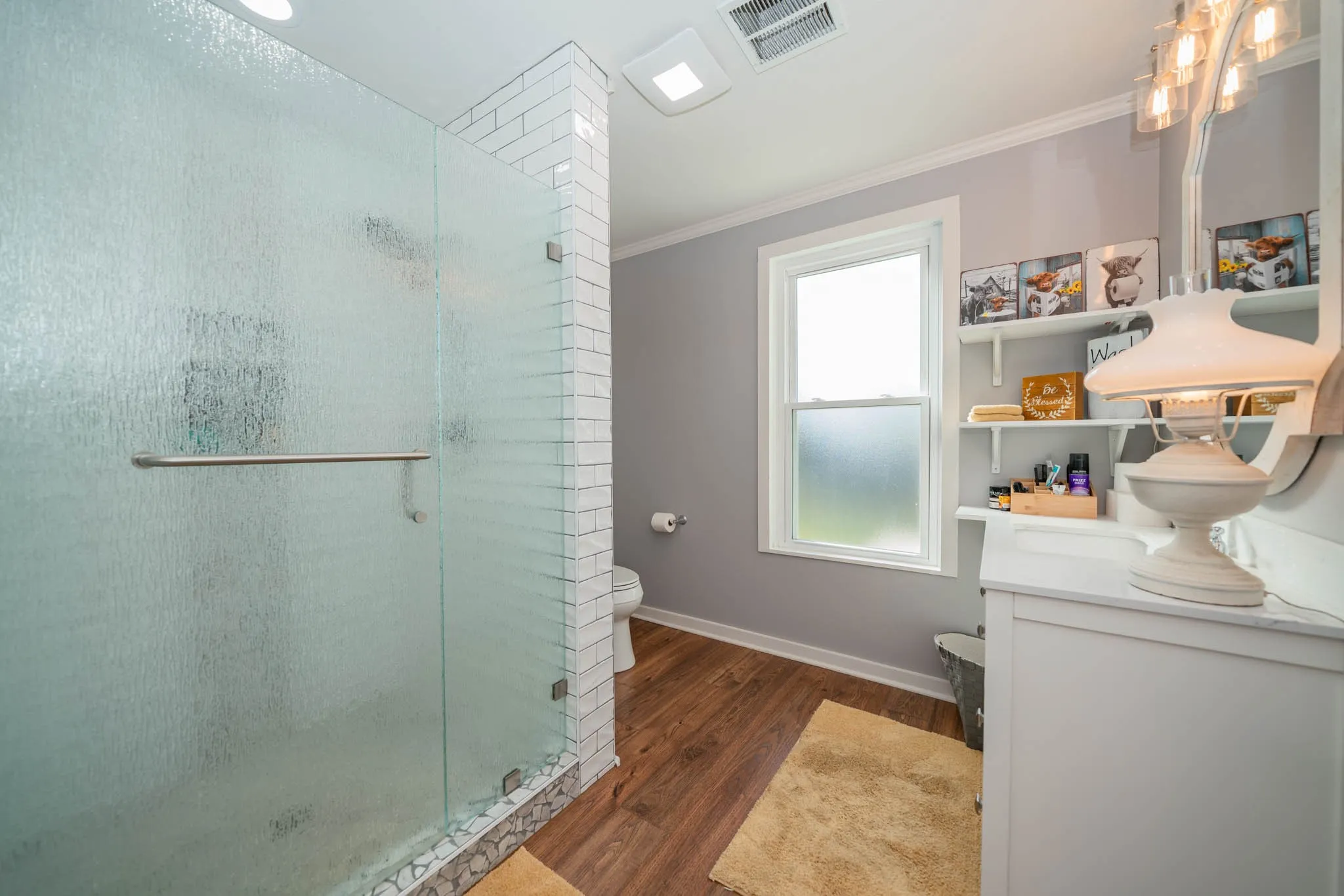 Bathroom featuring ornamental molding, a stall shower, dark wood-style flooring, and vanity