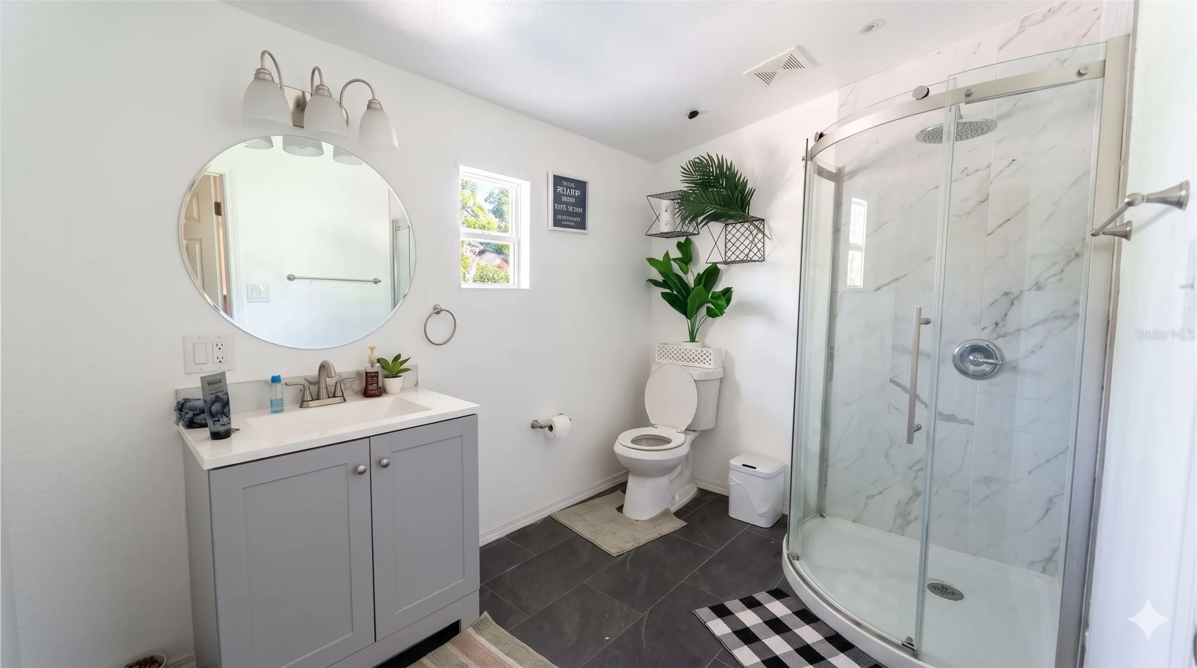 Bathroom with vanity, a shower stall, dark tile patterned flooring, and a textured ceiling