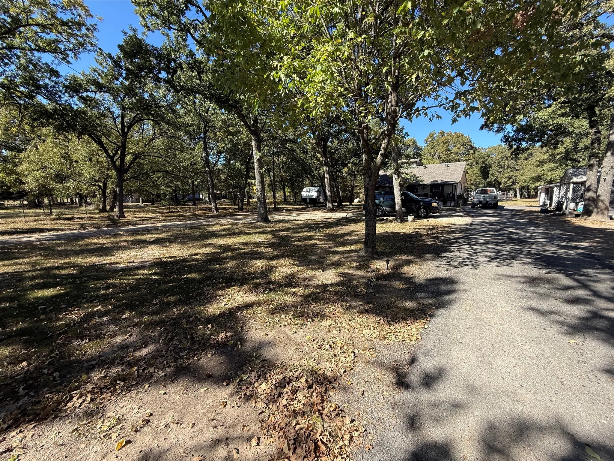 View of asphalt driveway with view of wooded area