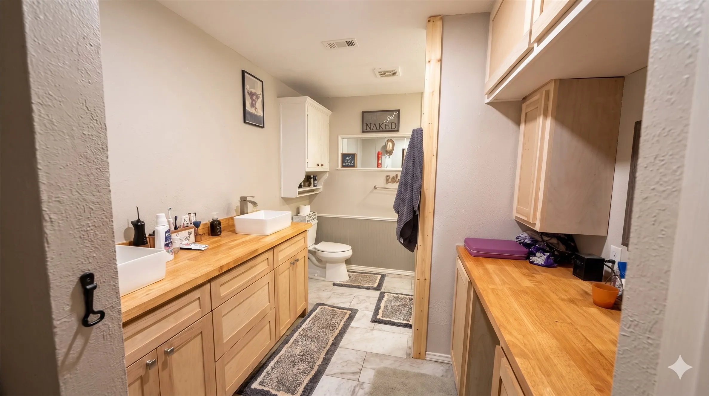 Bathroom with double vanity, a bathtub, and light marble finish floors