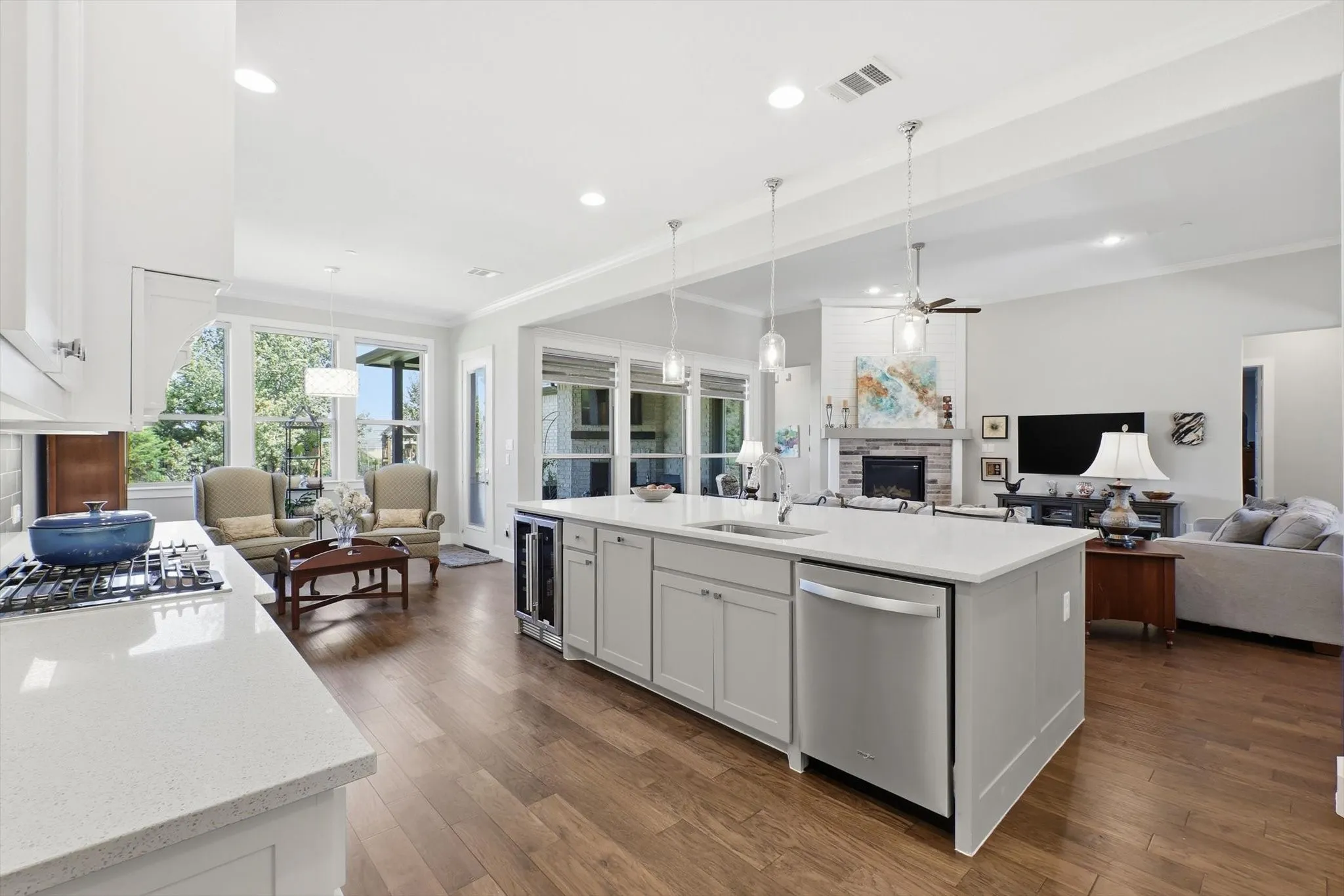 Kitchen island has a beverage/wine chiller and lovely pendant lighting that doesn't obstruct the view.